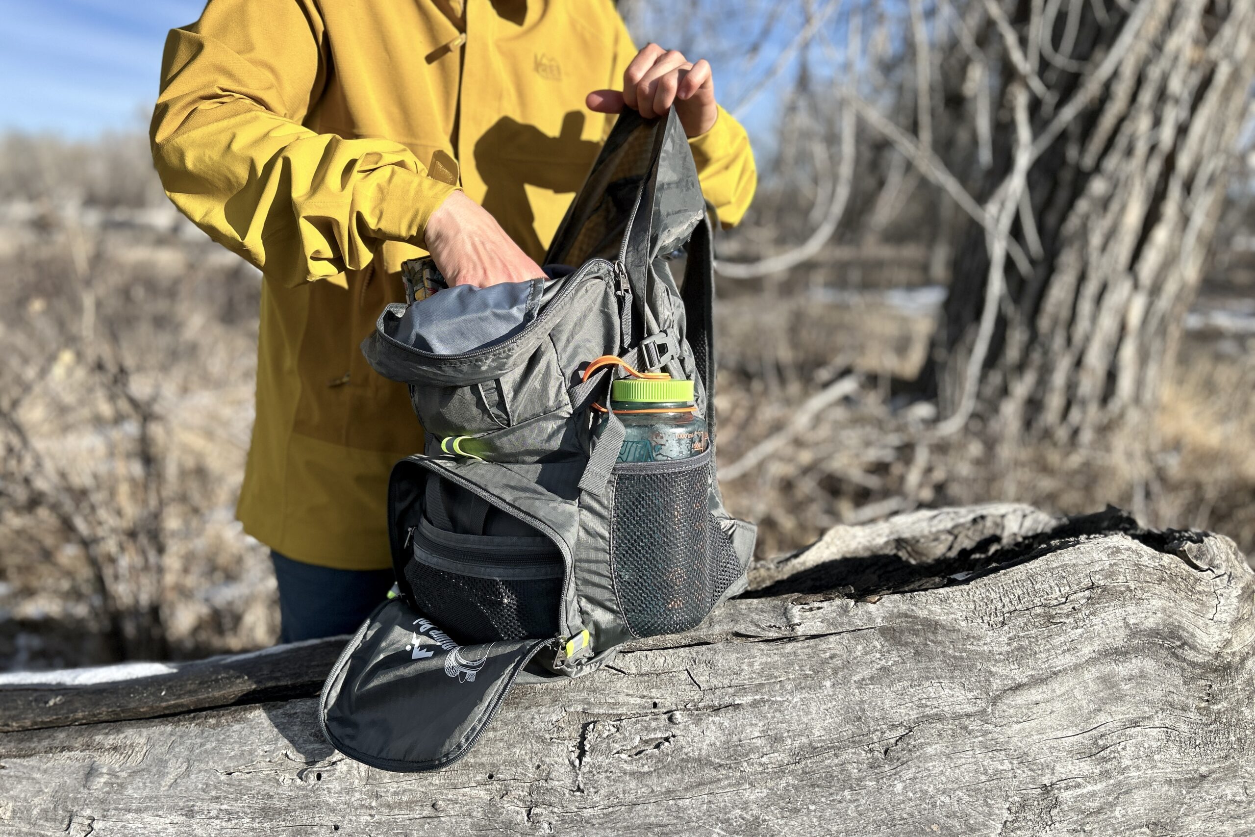 Closeup of a person pulling gear out of their backpack.