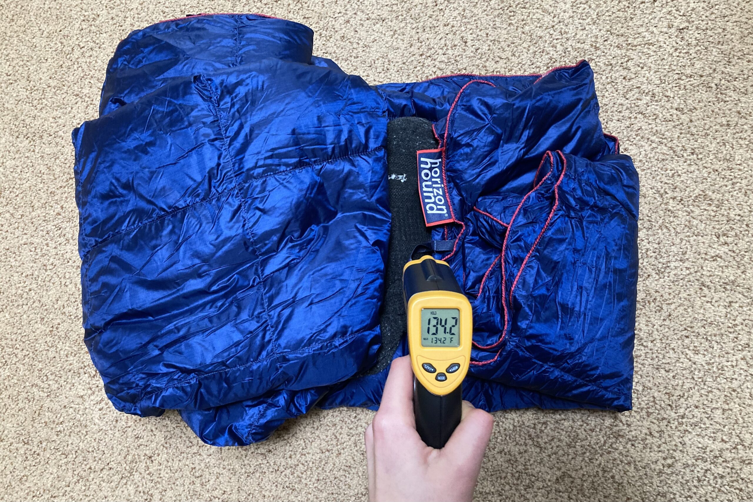 Displaying the reading on the infrared thermometer after the heat sock had been wrapped in the Horizon Hound Trek Blanket for 30 Min. The reading is 134.2F.