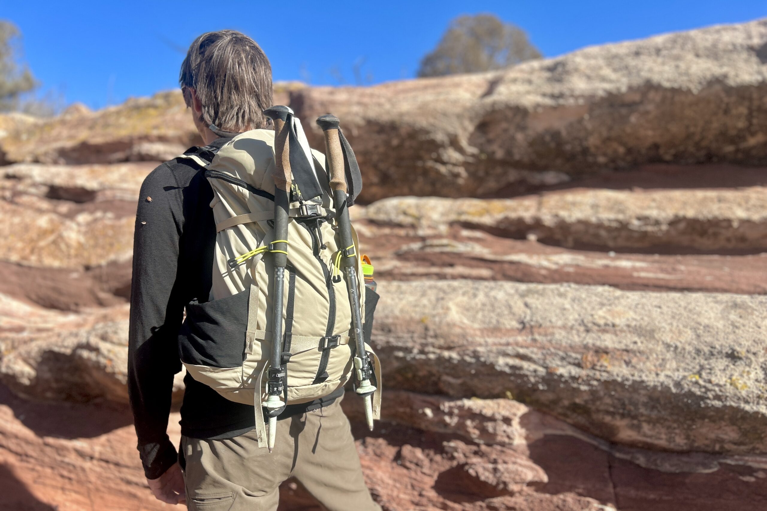 Close up of a man wearing a daypack in a desert setting.