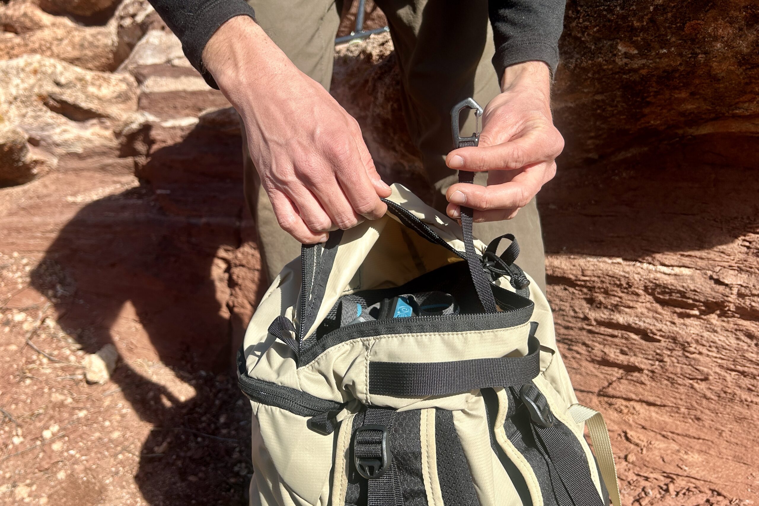 Close up of a person opening the brain of their backpack.