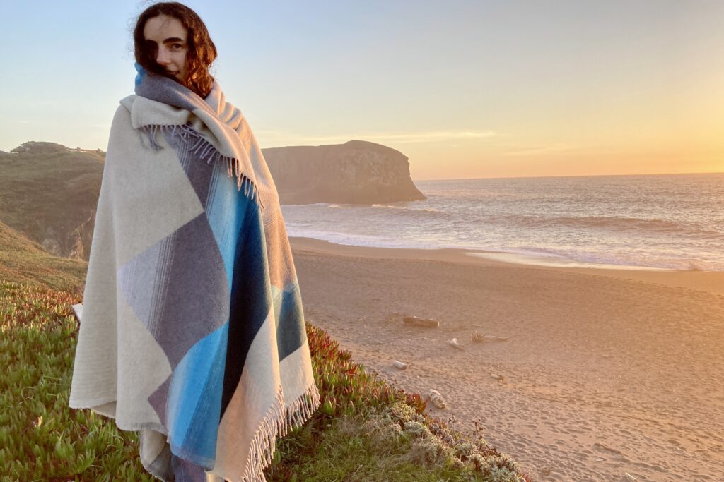 Women wrapped in the Sackcloth and Ashes blanket at the beach