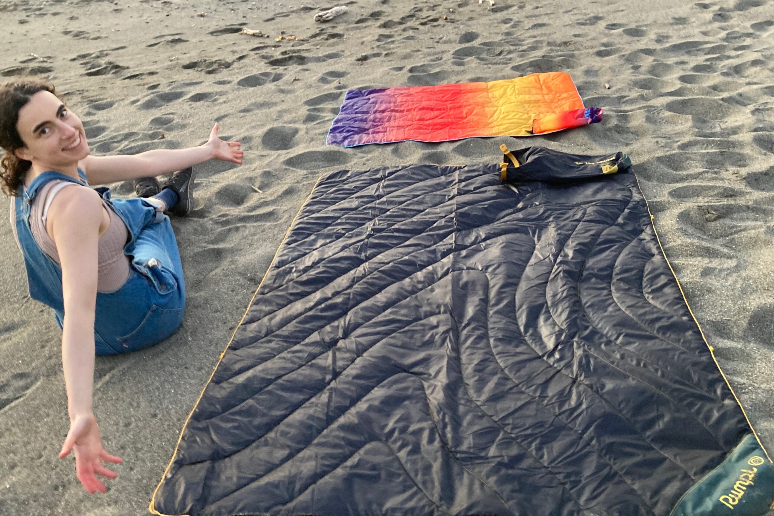 Person showing the size comparison of the Rumpl NanoLoft to the Rumpl Original Puffy Blanket.