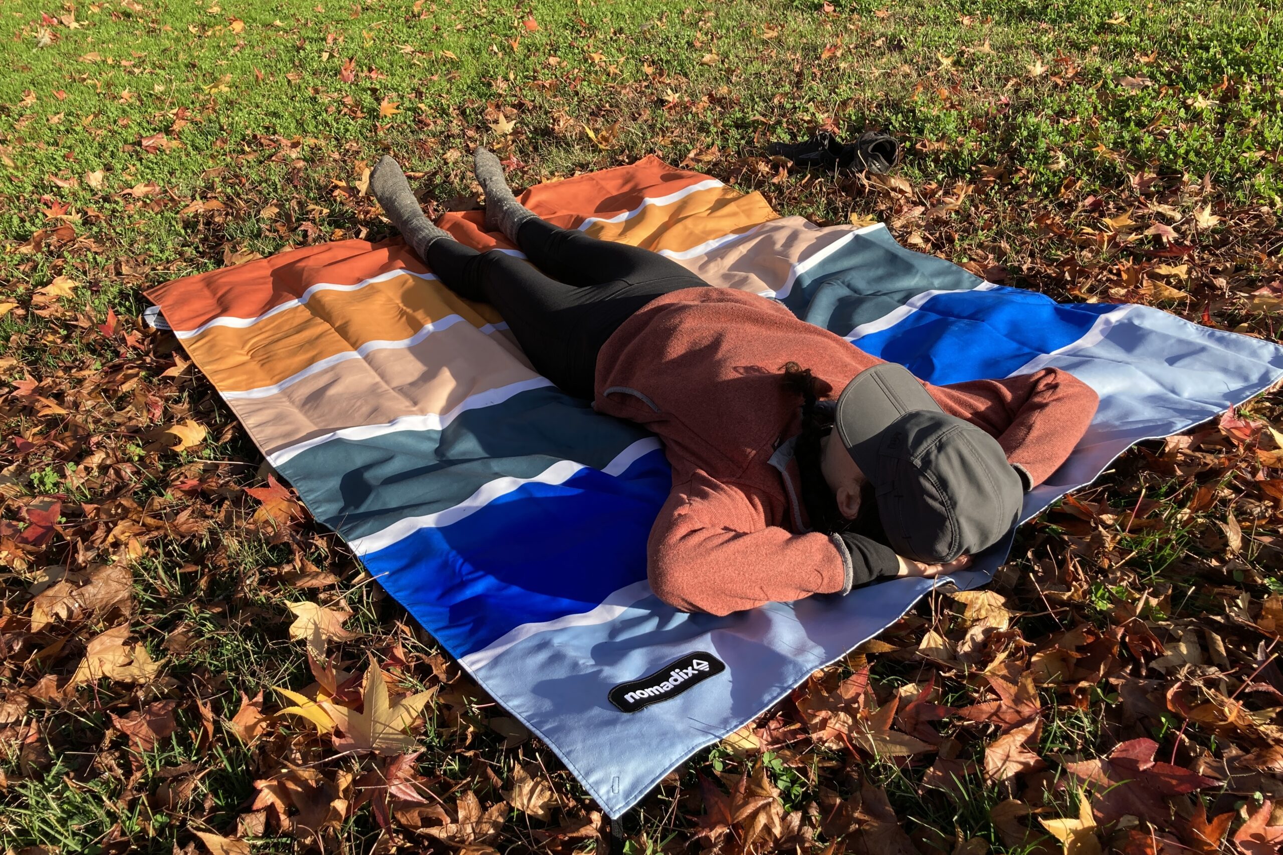 Women laying stretched out on the Nomadix Festival Blanket