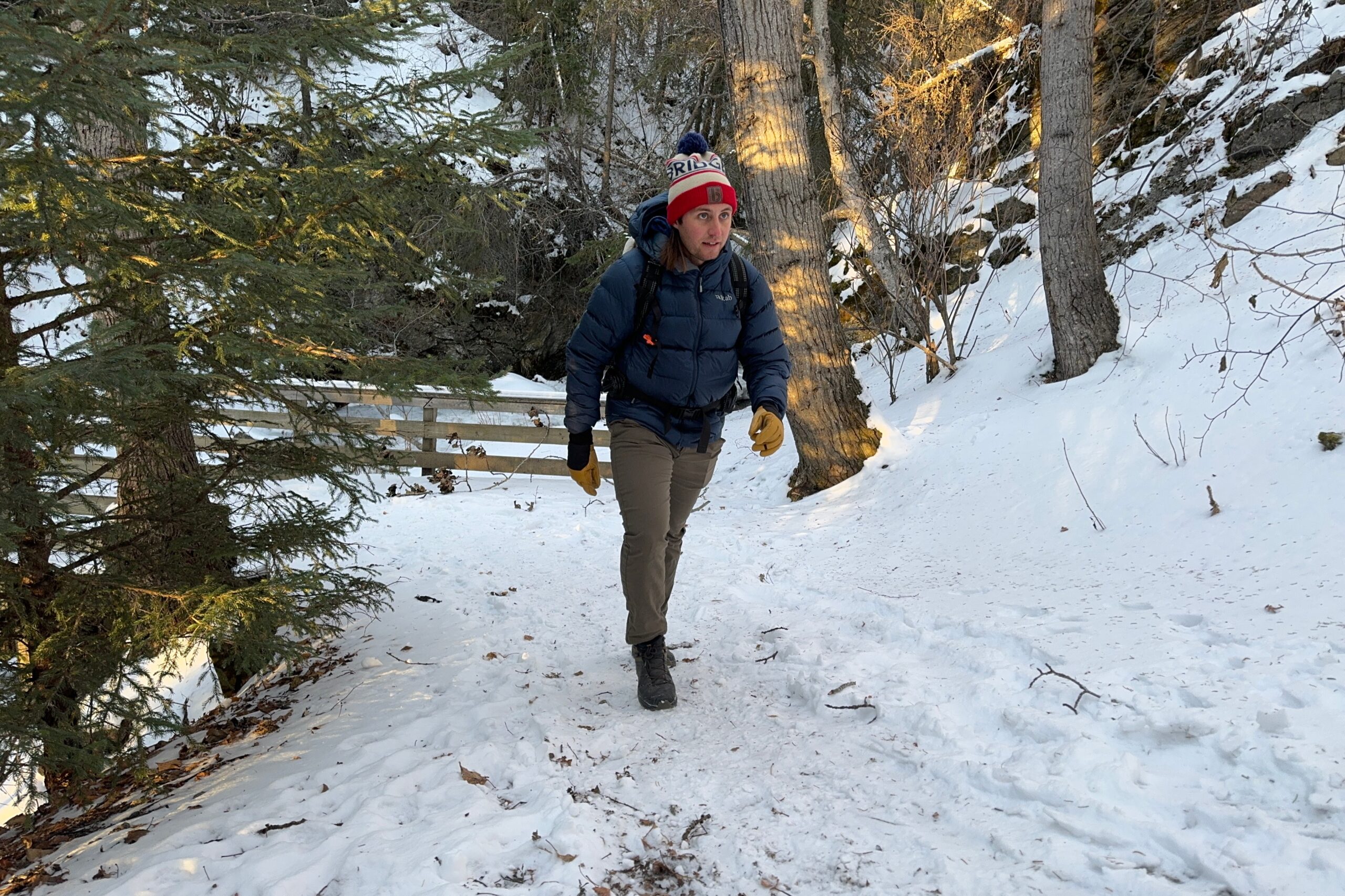 A man walks up a snowy trail.