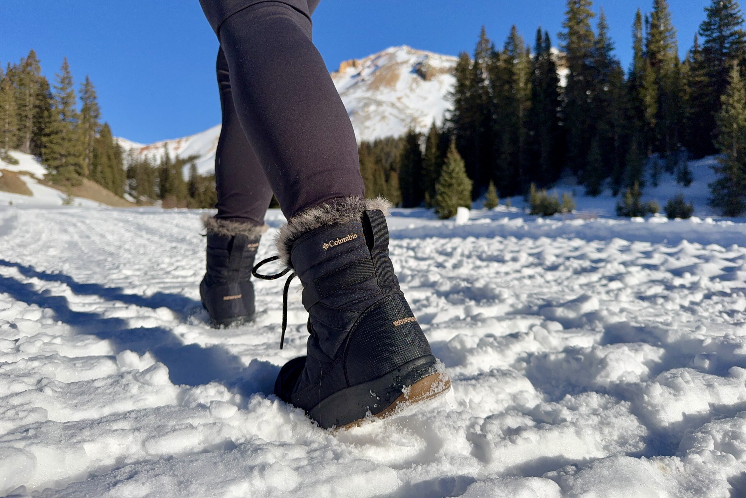 A close up of a person walking in the Minx Shorty boots in the snow.