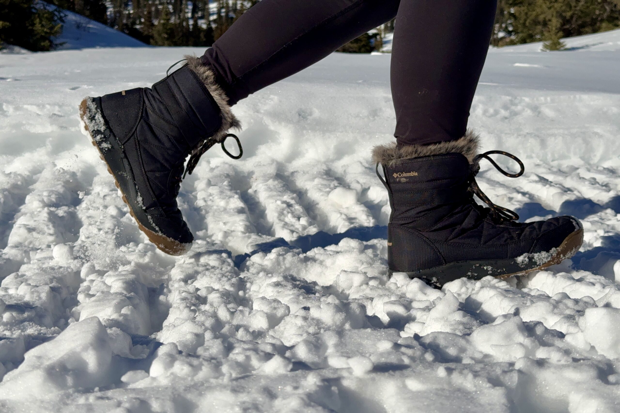 A close up of a person walking in the Minx Shorty boots in the snow.