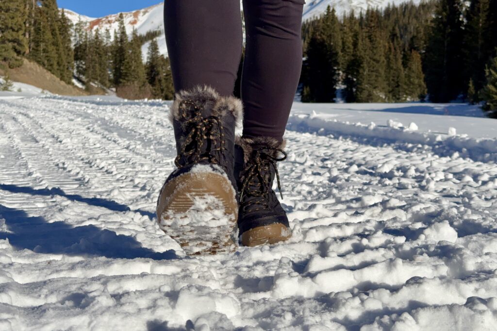 A close up of a person walking in the Minx Shorty boots in the snow.