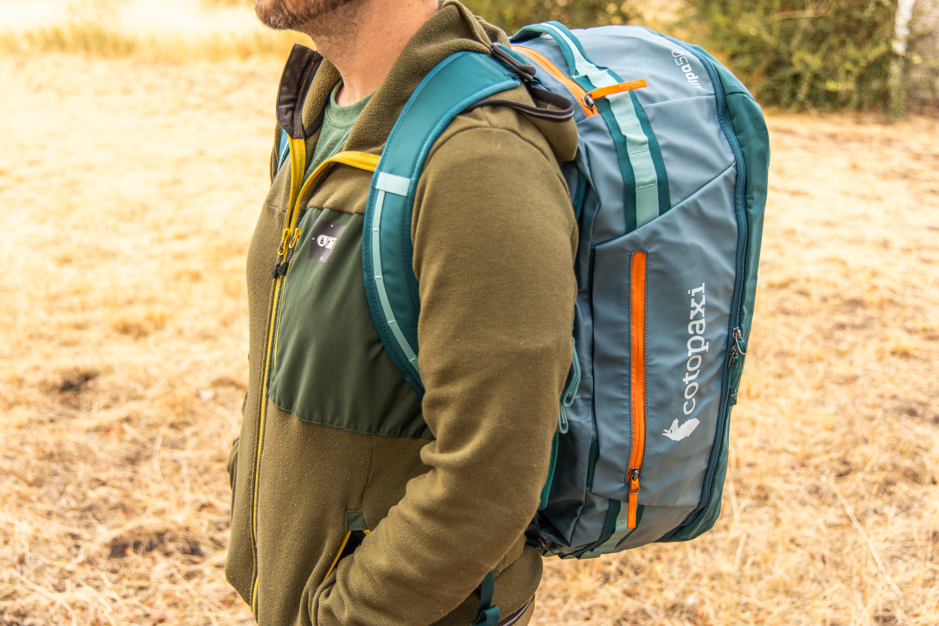 A man wears the Cotopaxi Allpa 50 duffel on his back in backpack mode.