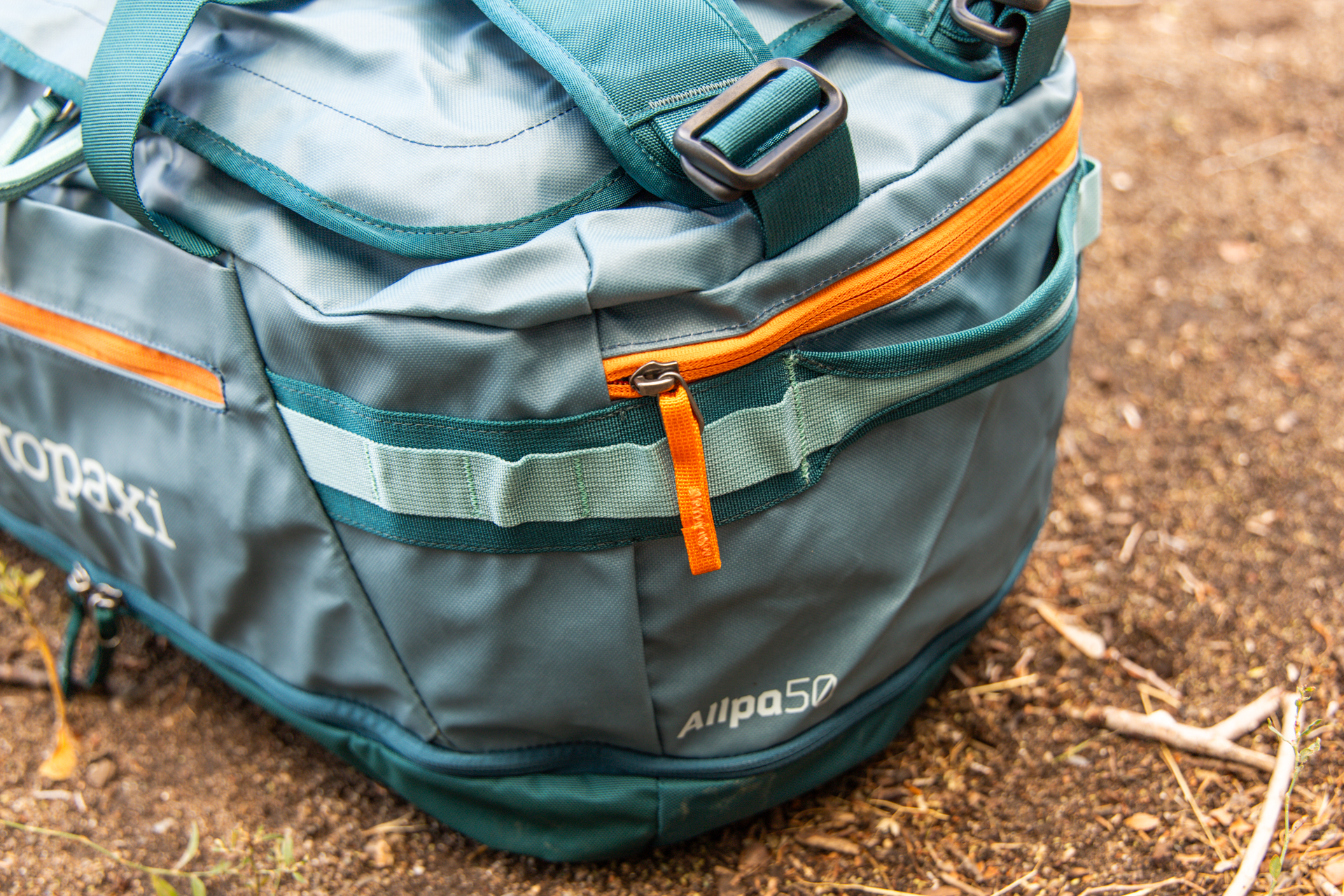 The zippered end pocket and end grab handles on the Cotopaxi Allpa 50L duffel.