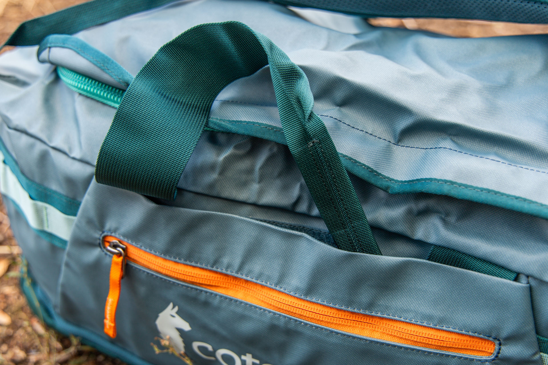 The top grab handles being stashed away in dedicated pockets on the side of the Cotopaxi Allpa 50 Duffel.