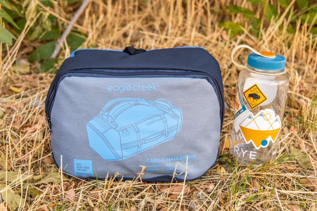 The Eagle Creek Cargo Hauler 60L duffel packed into its own pocket and placed next to a Nalgene for size comparison.