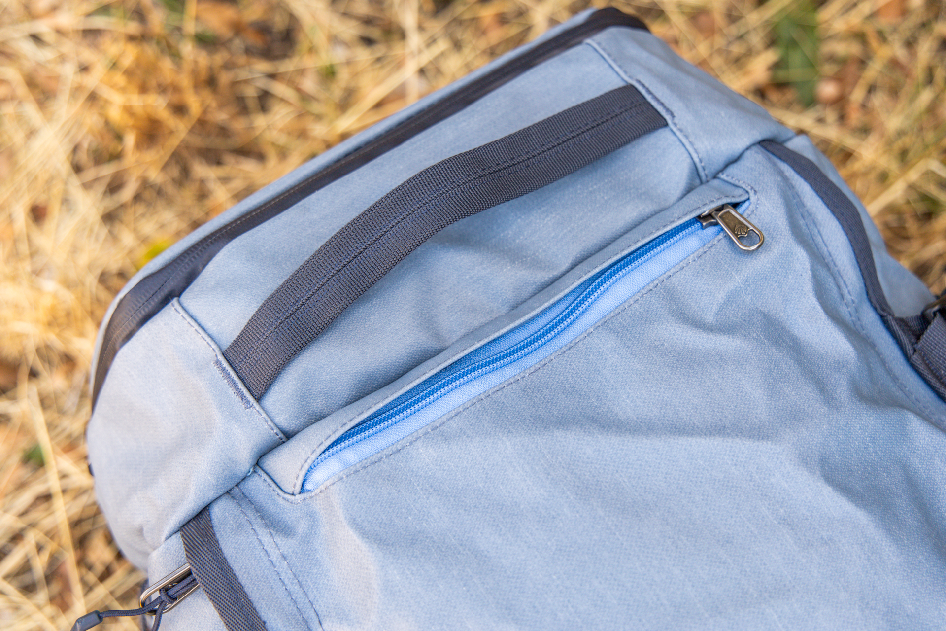 A grab handle and zipped up stash compartment with the pack straps stowed.