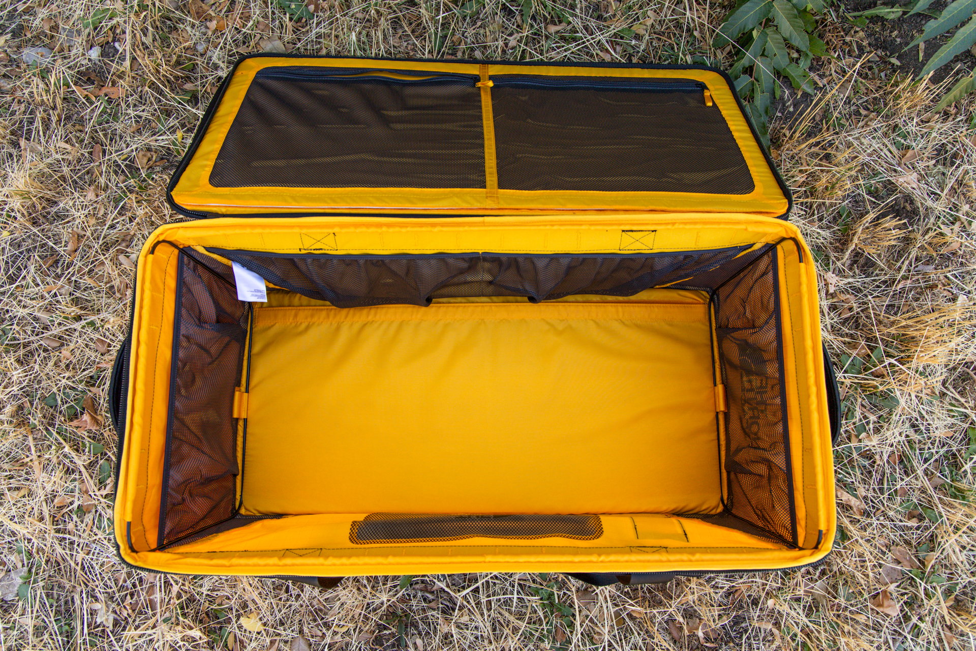 The Gear Box opened wide to show a spacious inner compartment, mesh zipper pockets on the inside of the lid, and mesh drop pockets along the inside interior.