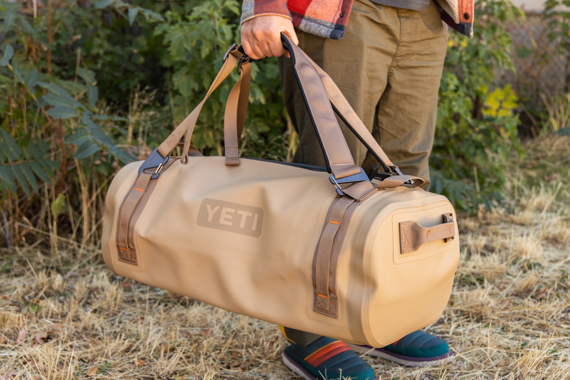 A man carries the Yeti Panga via the multi-use duffel and pack straps.