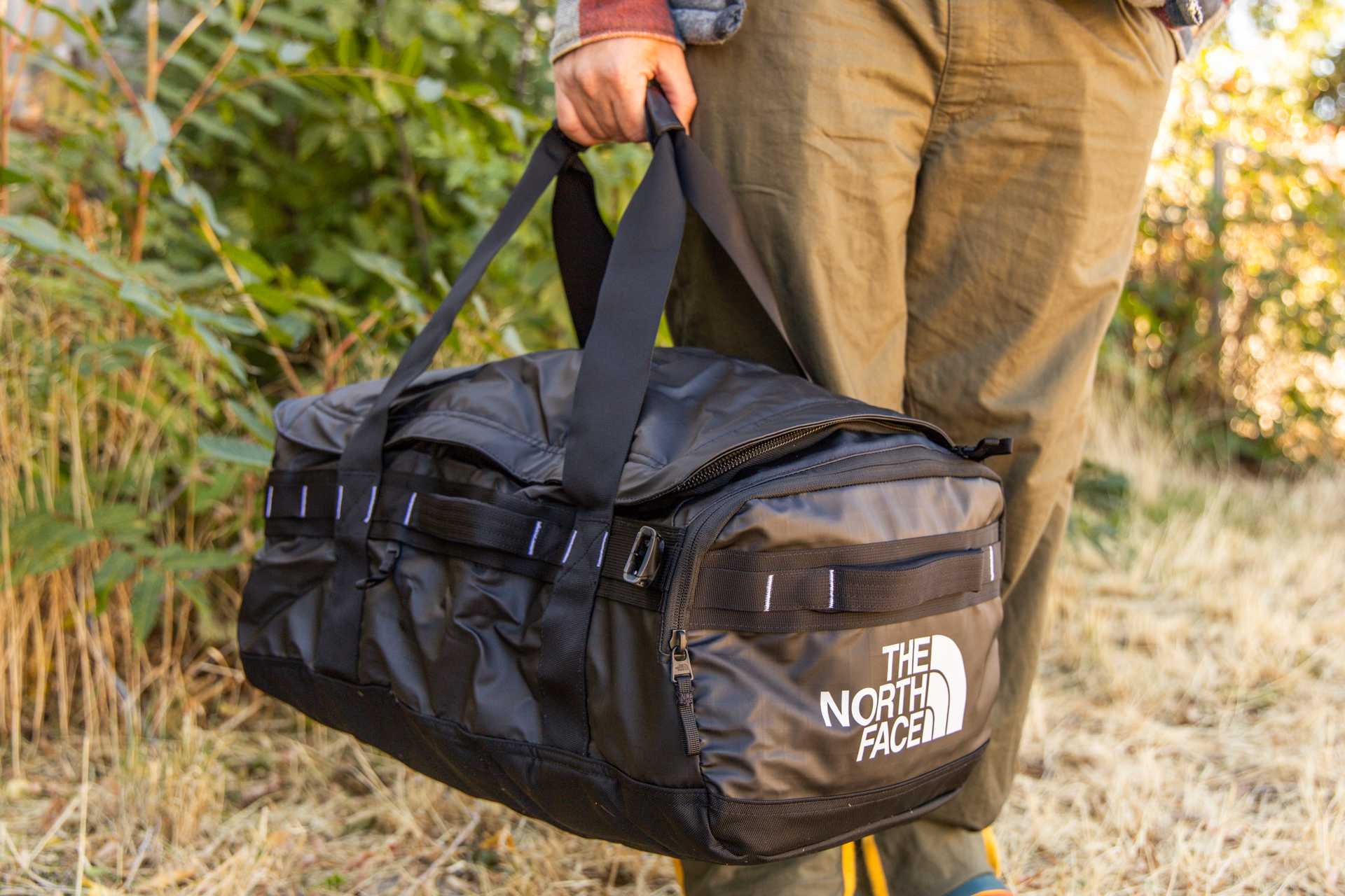 A man carries the Voyager duffel with the duffel handles; pack straps stowed.