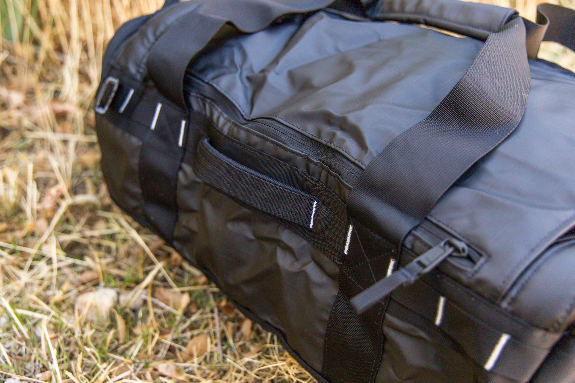 The durable and comfortable grab handle and the laptop pocket zipper in the lid.