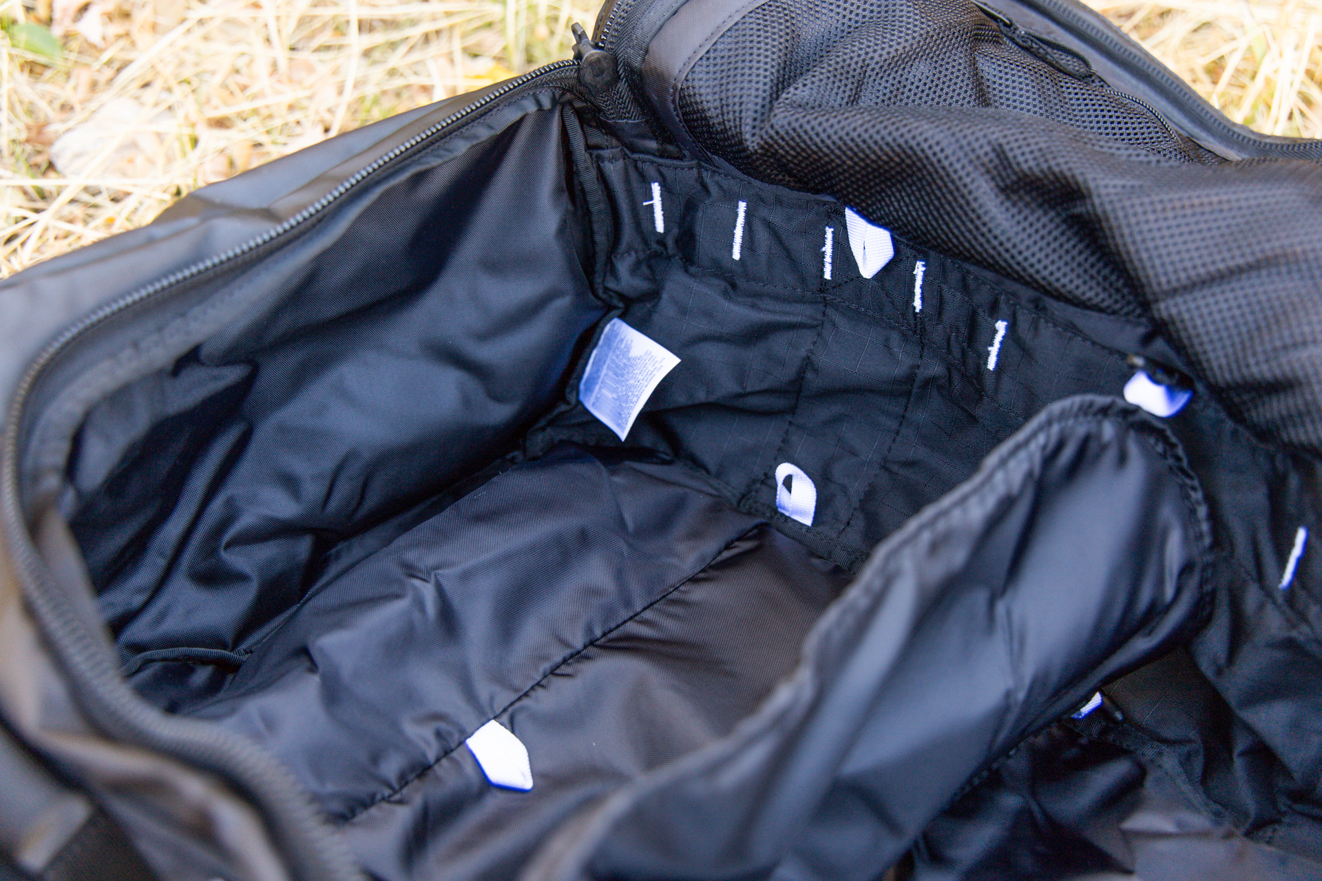 The inside of the duffel showing the divider positioned in the middle and the additional attachment points.