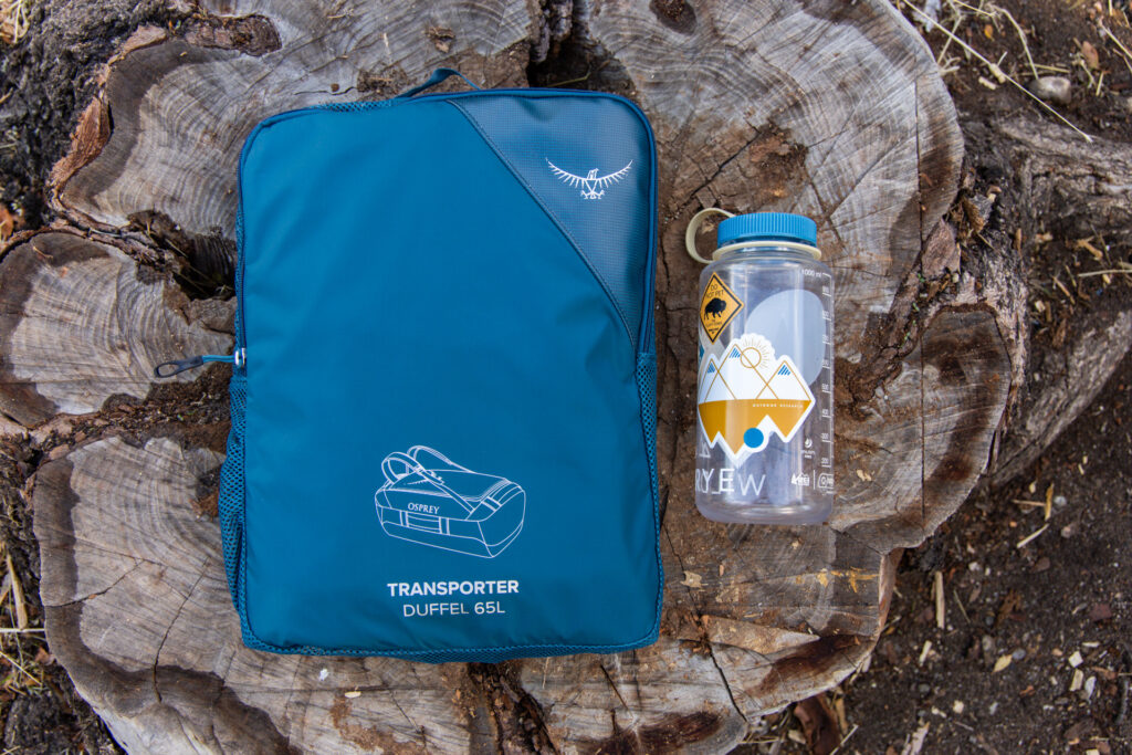 The Osprey Transporter packed in its accompanying storage pouch next to a Nalgene for size reference.