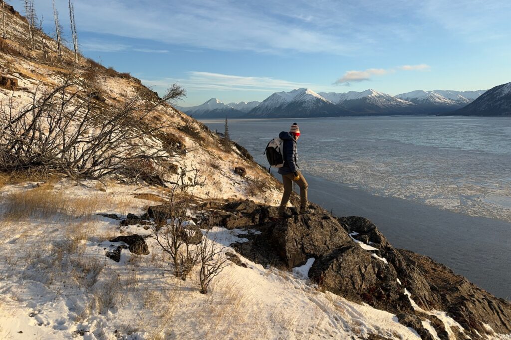 A man looks over a mountain and ocean view.