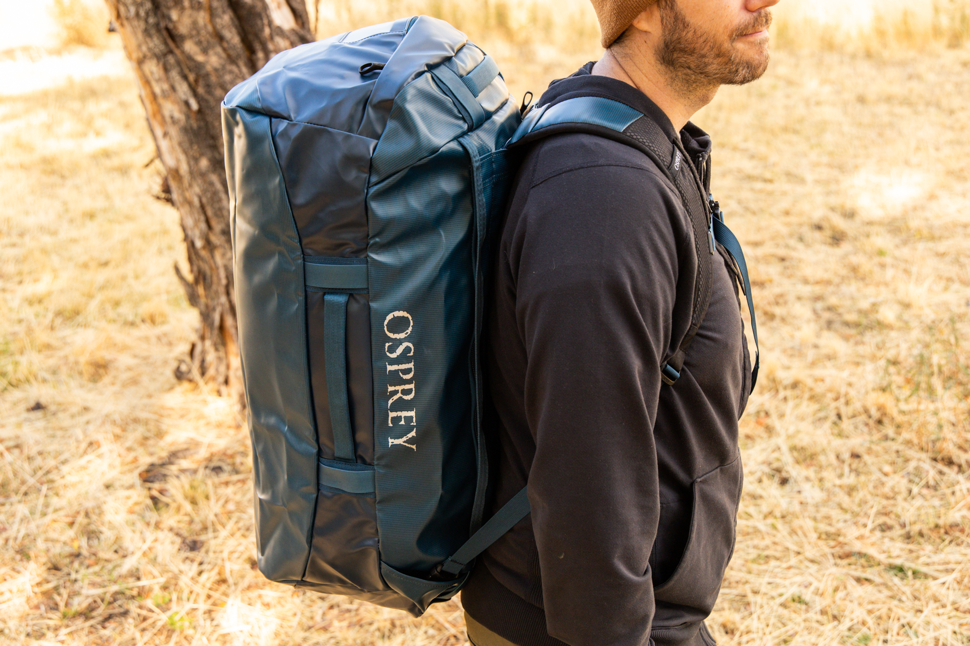 A man carrying the Osprey Transporter duffel as a backpack.