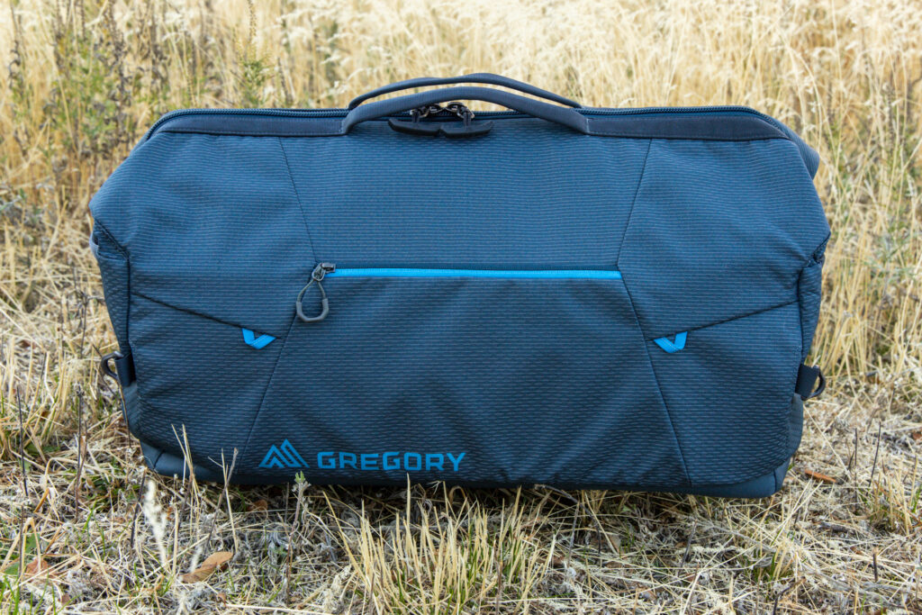 A side view of the Gregory Alpaca Wide Mouth 50 duffel with exterior pocket and top grab handle, but no shoulder strap attached.