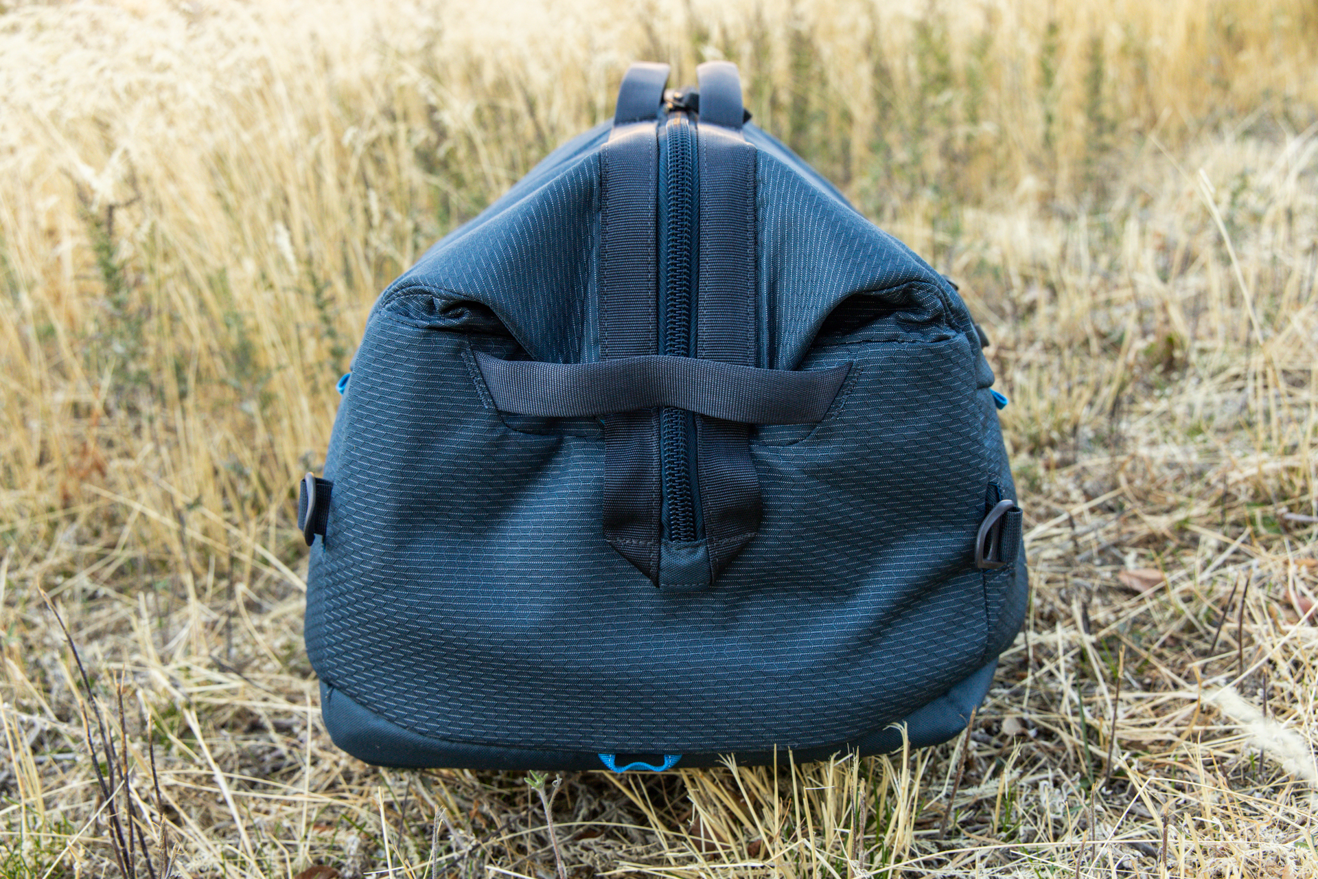 The end of the Gregory Alpaca Wide Mouth 50 duffel with opening zipped shut and tucked behind the cargo handle.