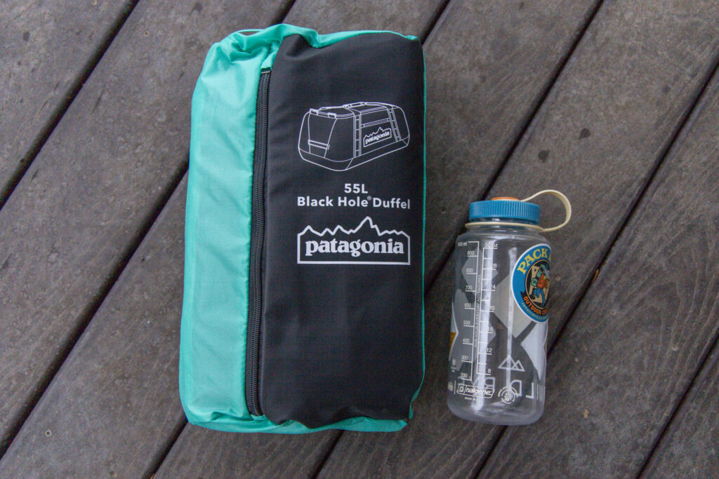 The Patagonia Black Hole packed into its own pocket placed next to a Nalgene for size reference.