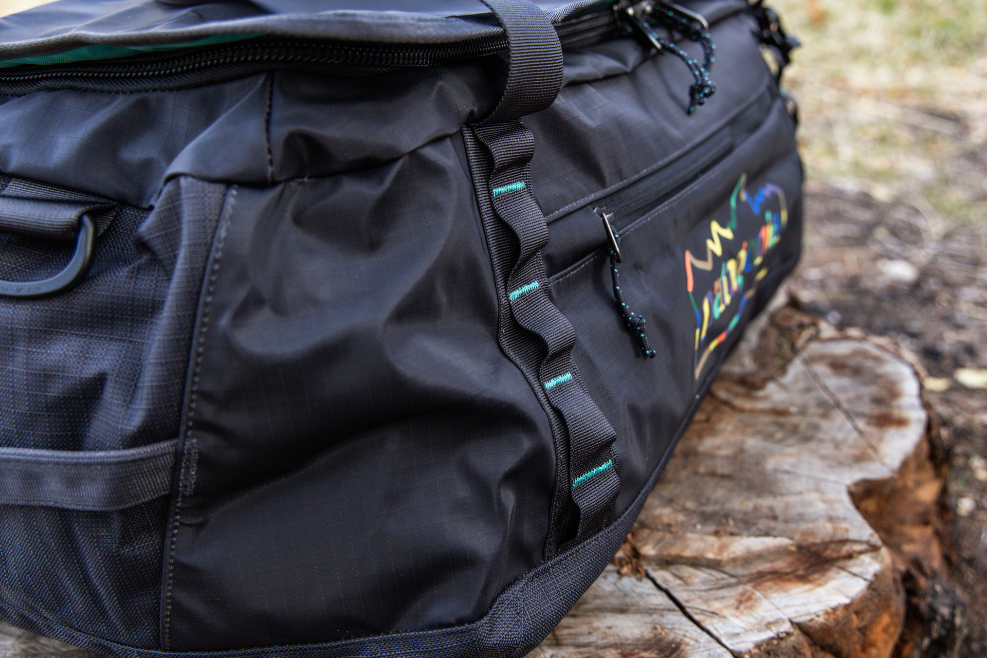 A close-up of the Black Hole's exterior zipper access to the accessory pocket and webbing lash points.