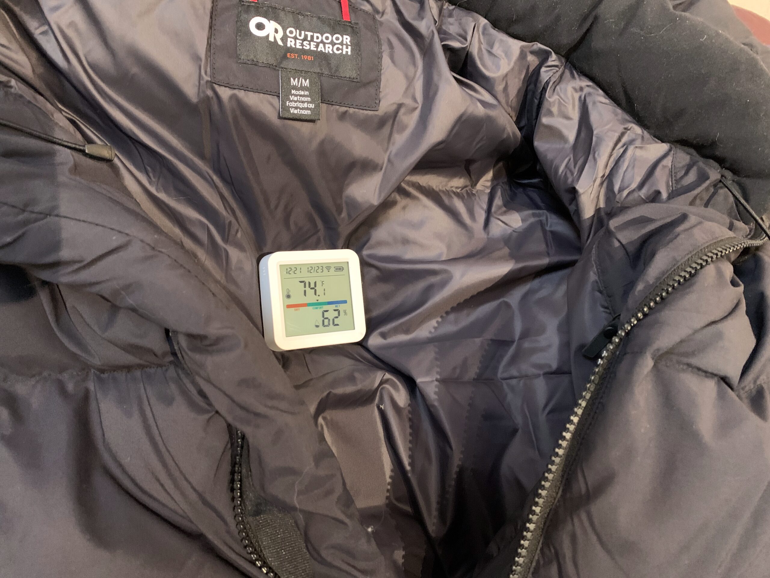 a thermometer placed on the inside of a down jacket