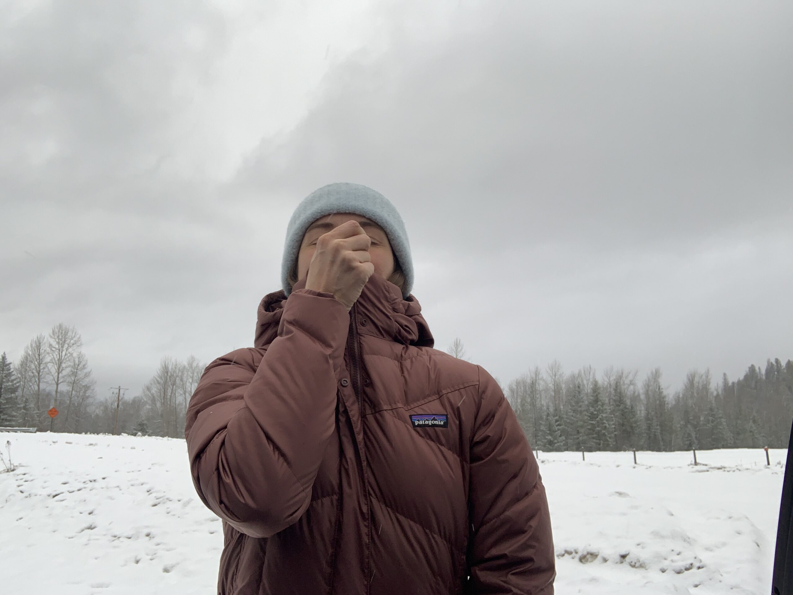 a women zipping up the patagonia down with it parka