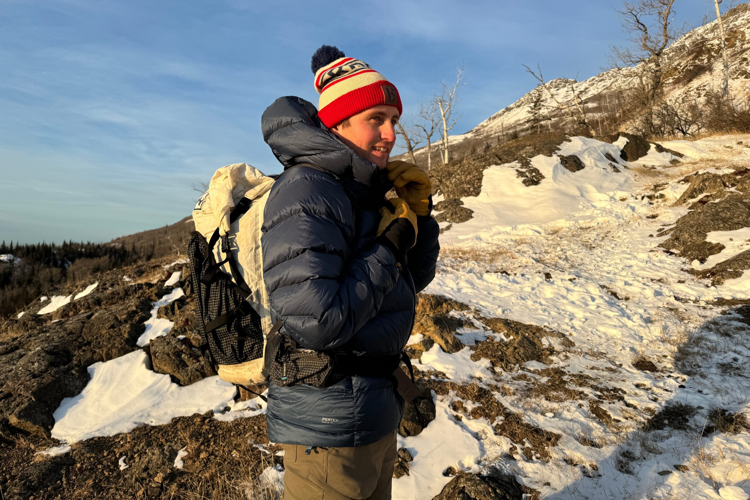 A man zips up his down jacket