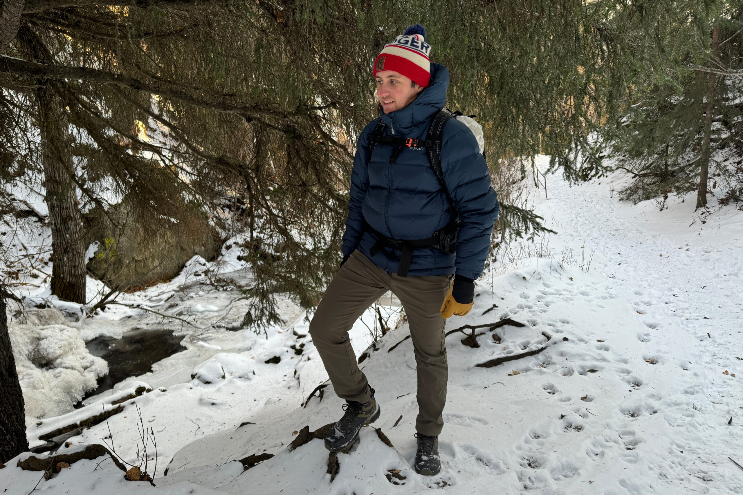 A man stands next to an ice covered river