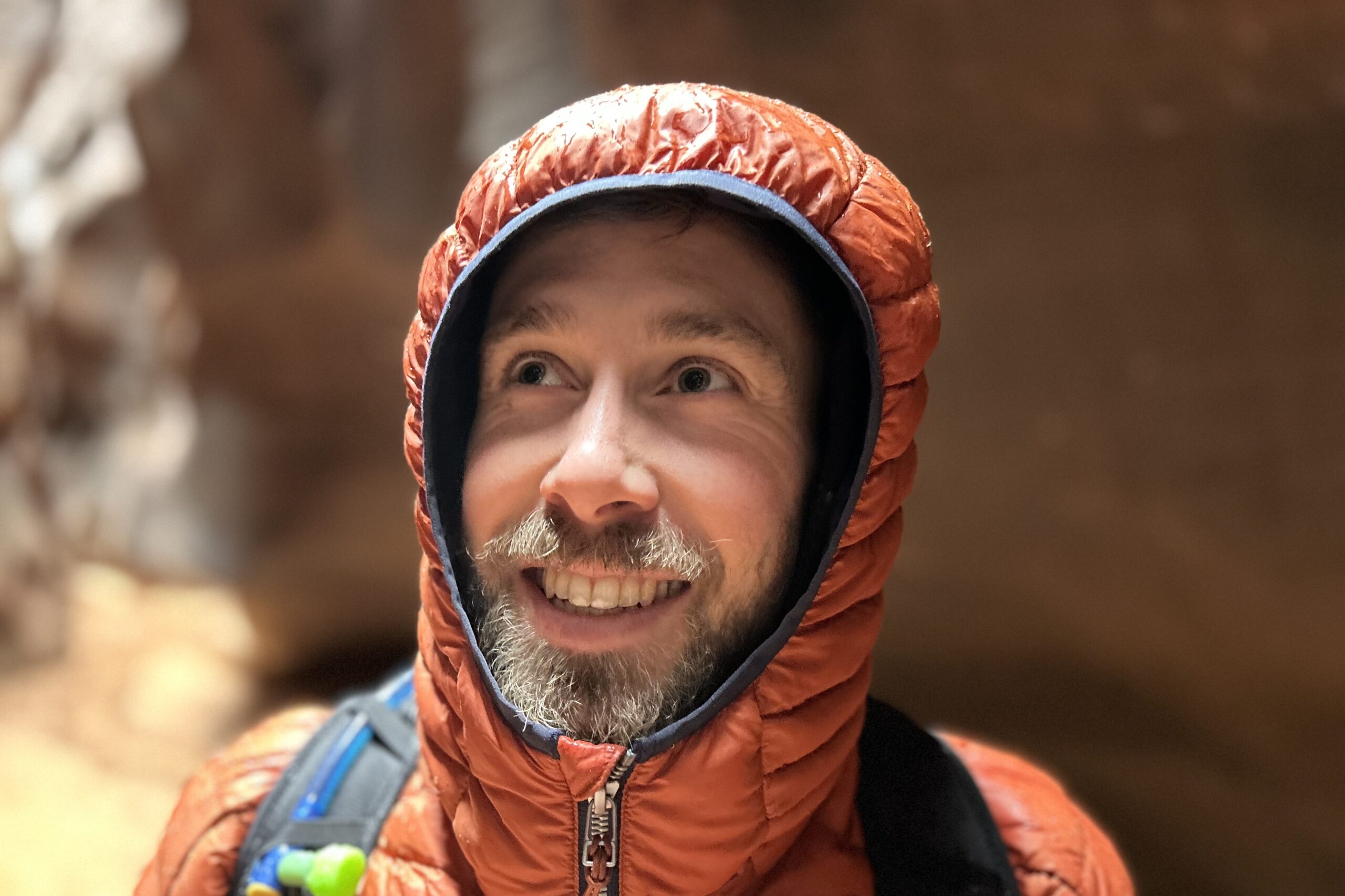 Close up of a man in a hooded puffy jacket.