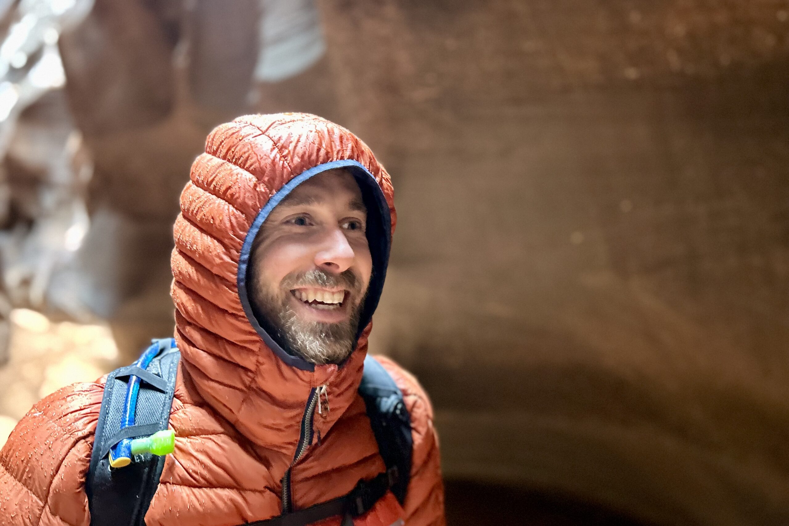 Close up of a man in a hooded puffy jacket.