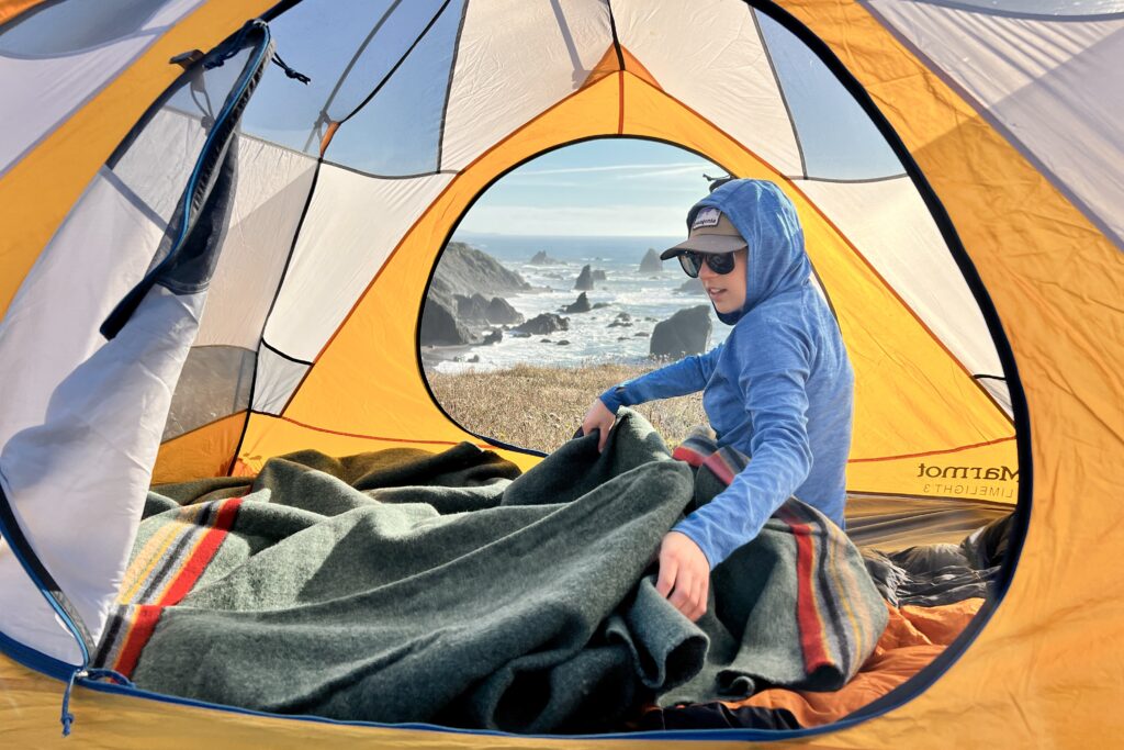 Person in tent laying out the Pendleton Yakima Camp Blanket.