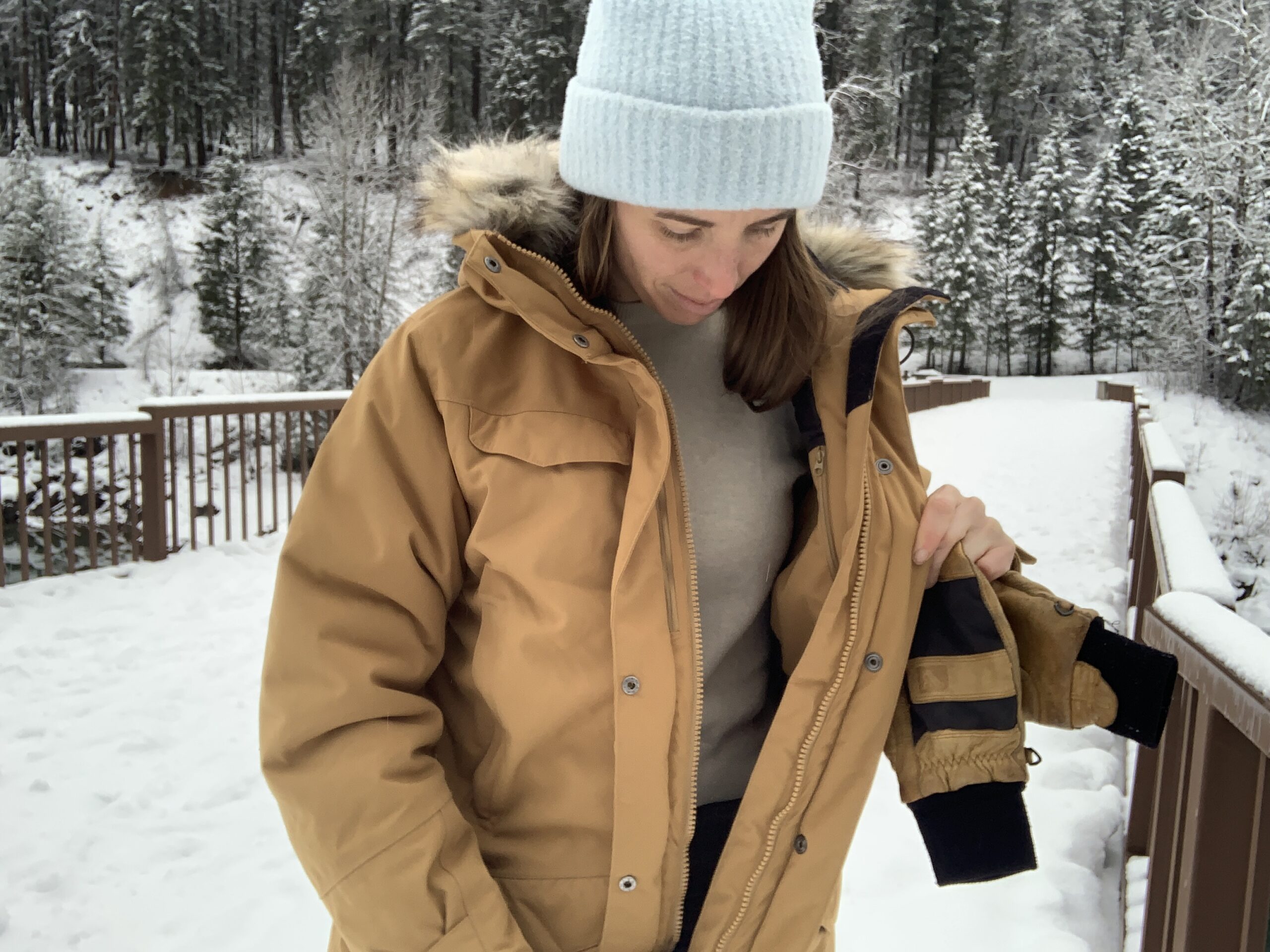 a woman unzips the fjallraven nuuk winter jacket