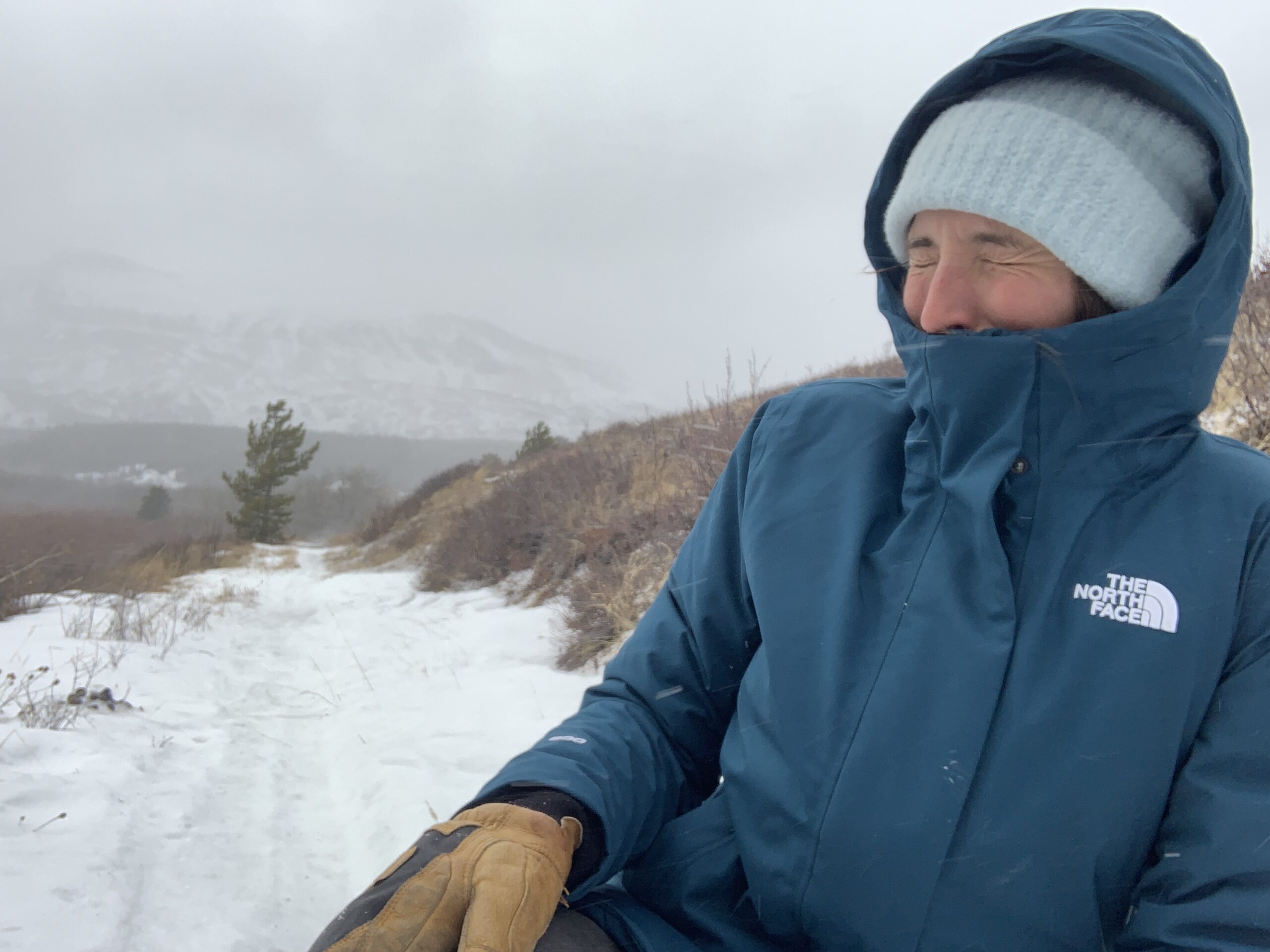 a person faces into the wind while testing the north face arctic winter jacket