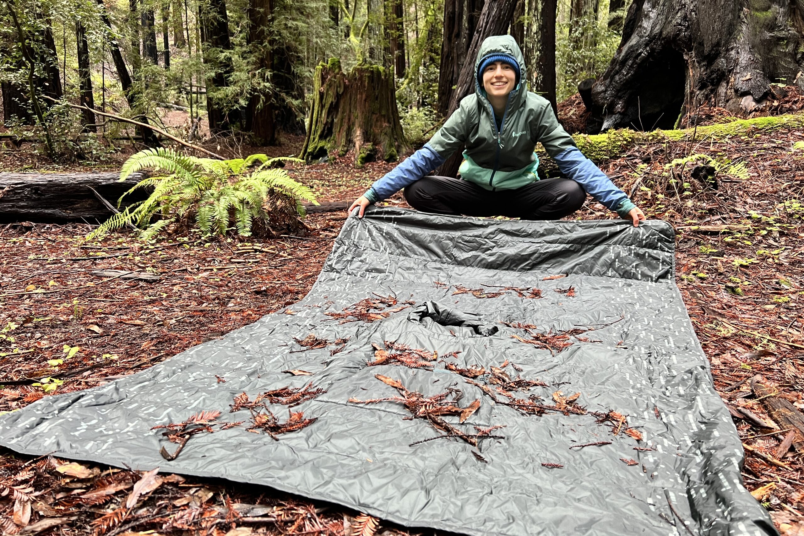 Person getting prepared to shake debris off of the Therm-a-Rest Honcho Poncho.