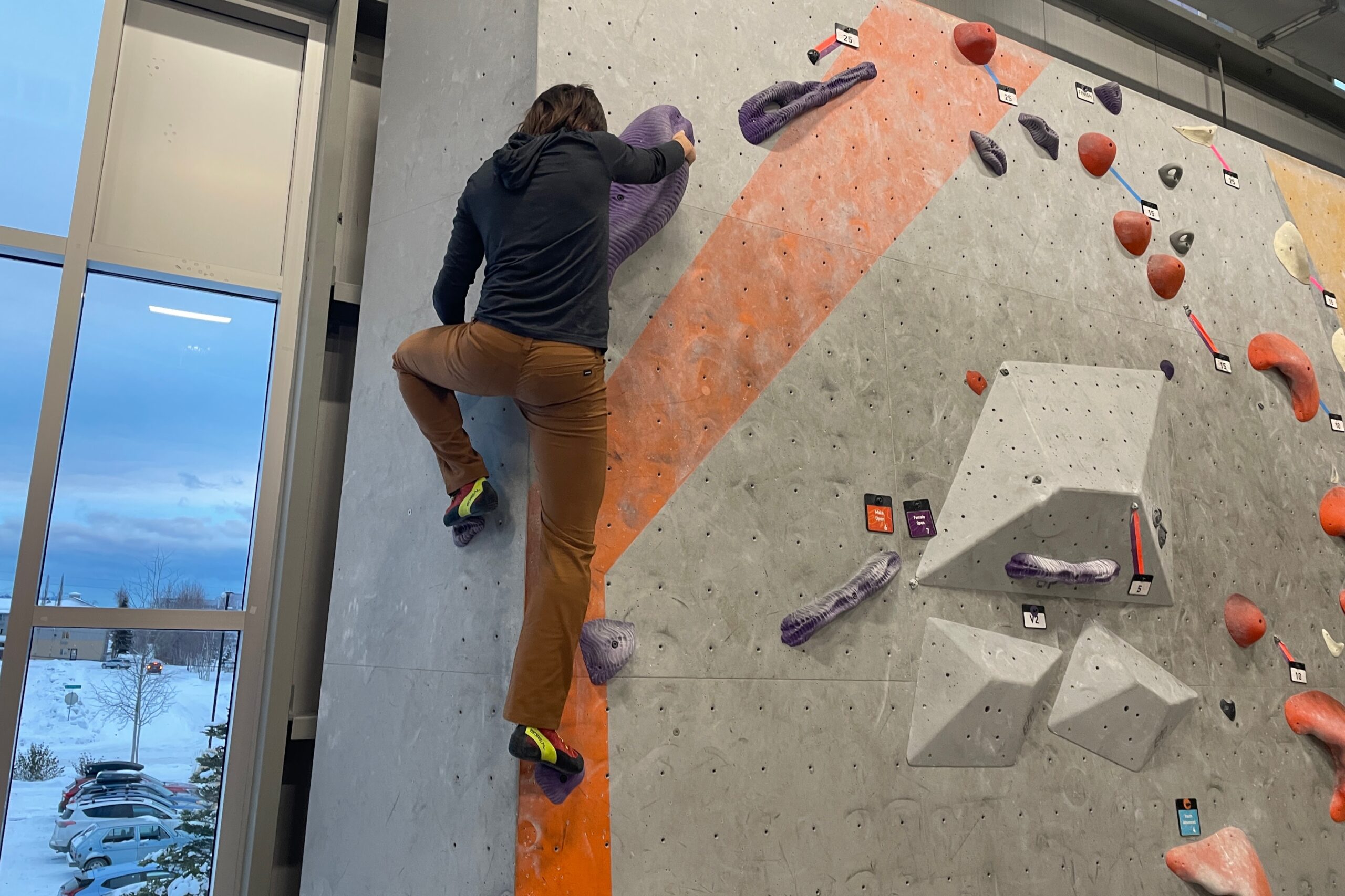 A man boulders in a climbing gym.