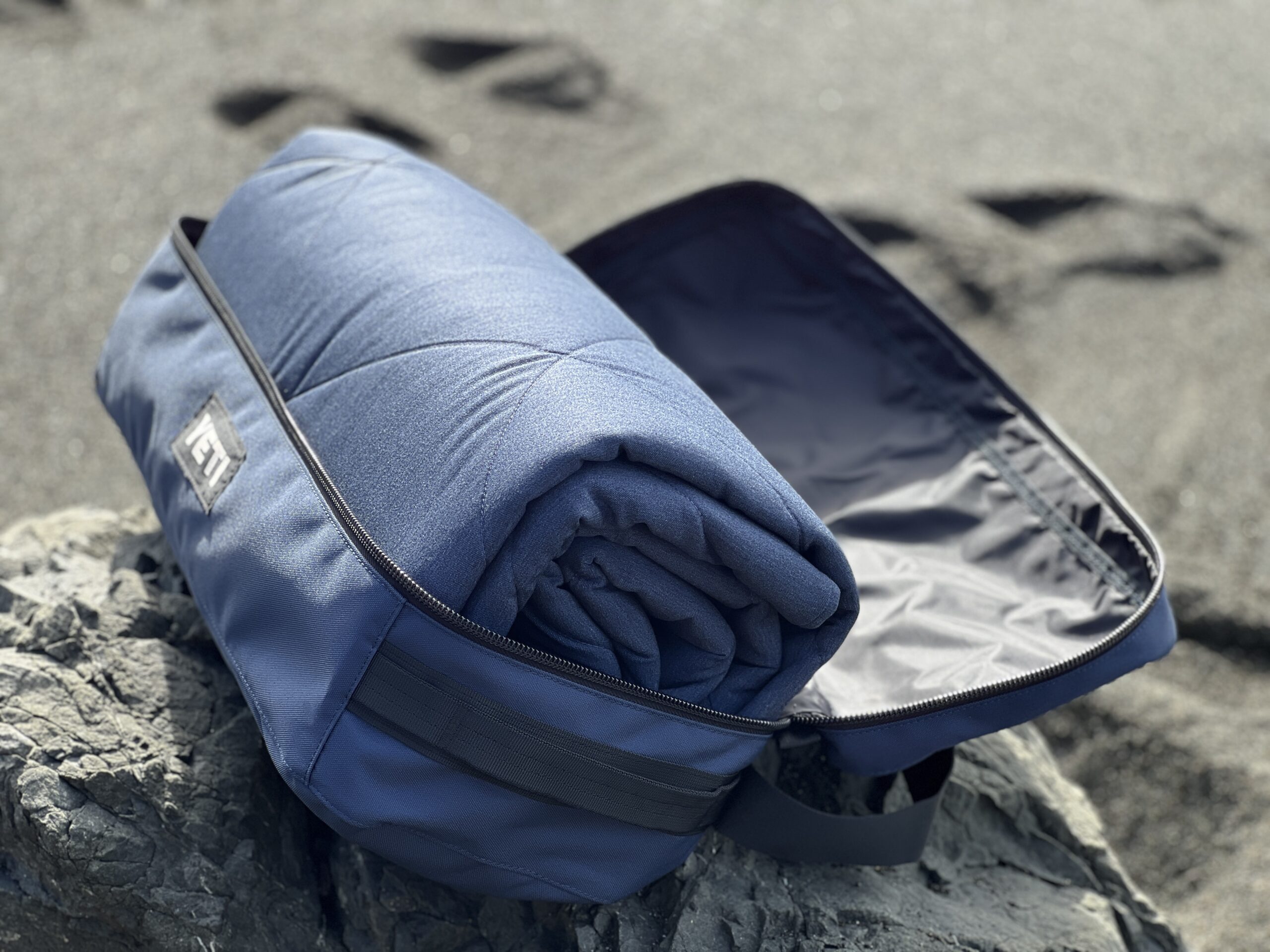 The Yeti Lowlands Blanket rolled up in its durable case, with the top open.