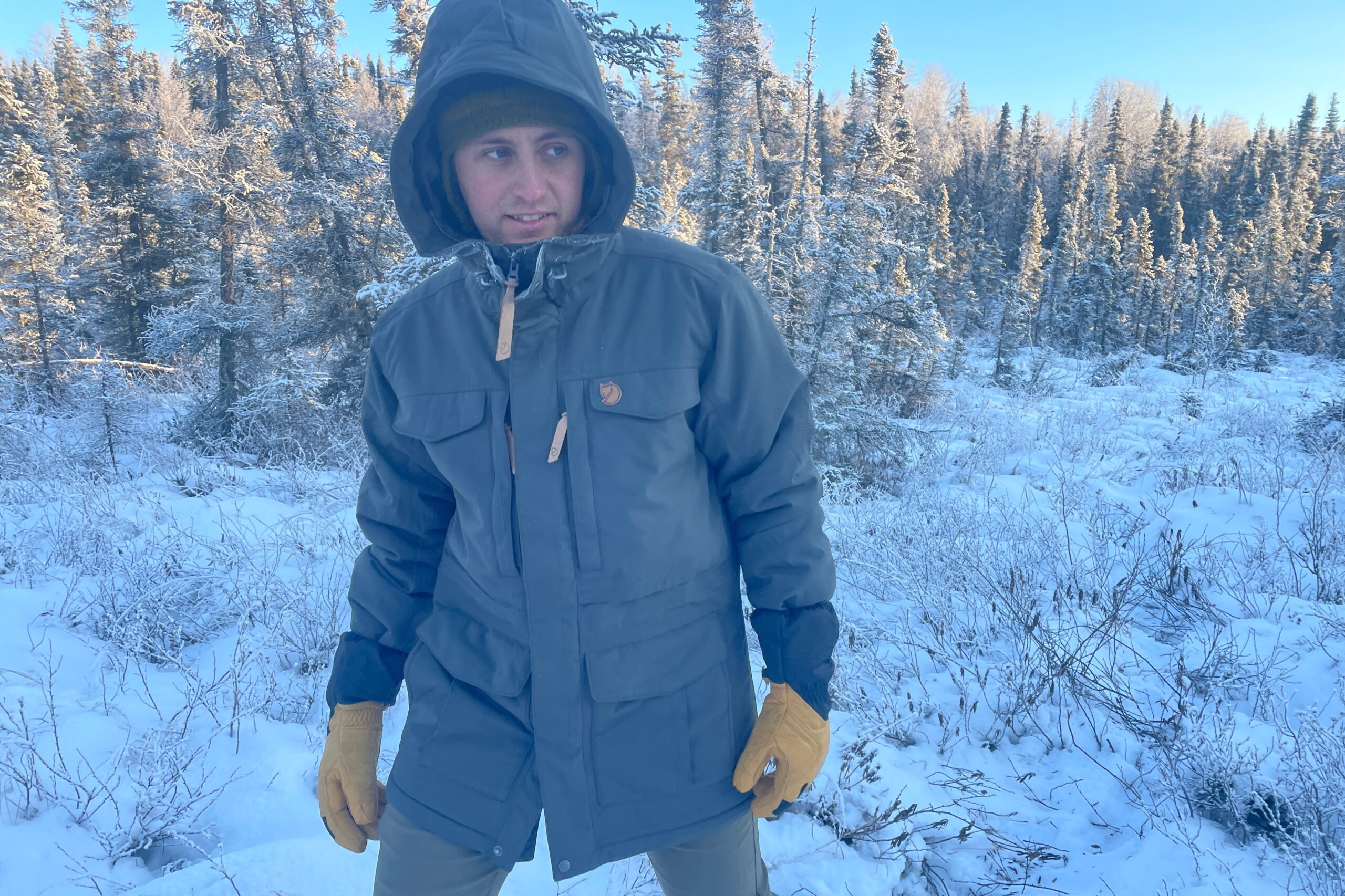 A man walks through a snowy forest