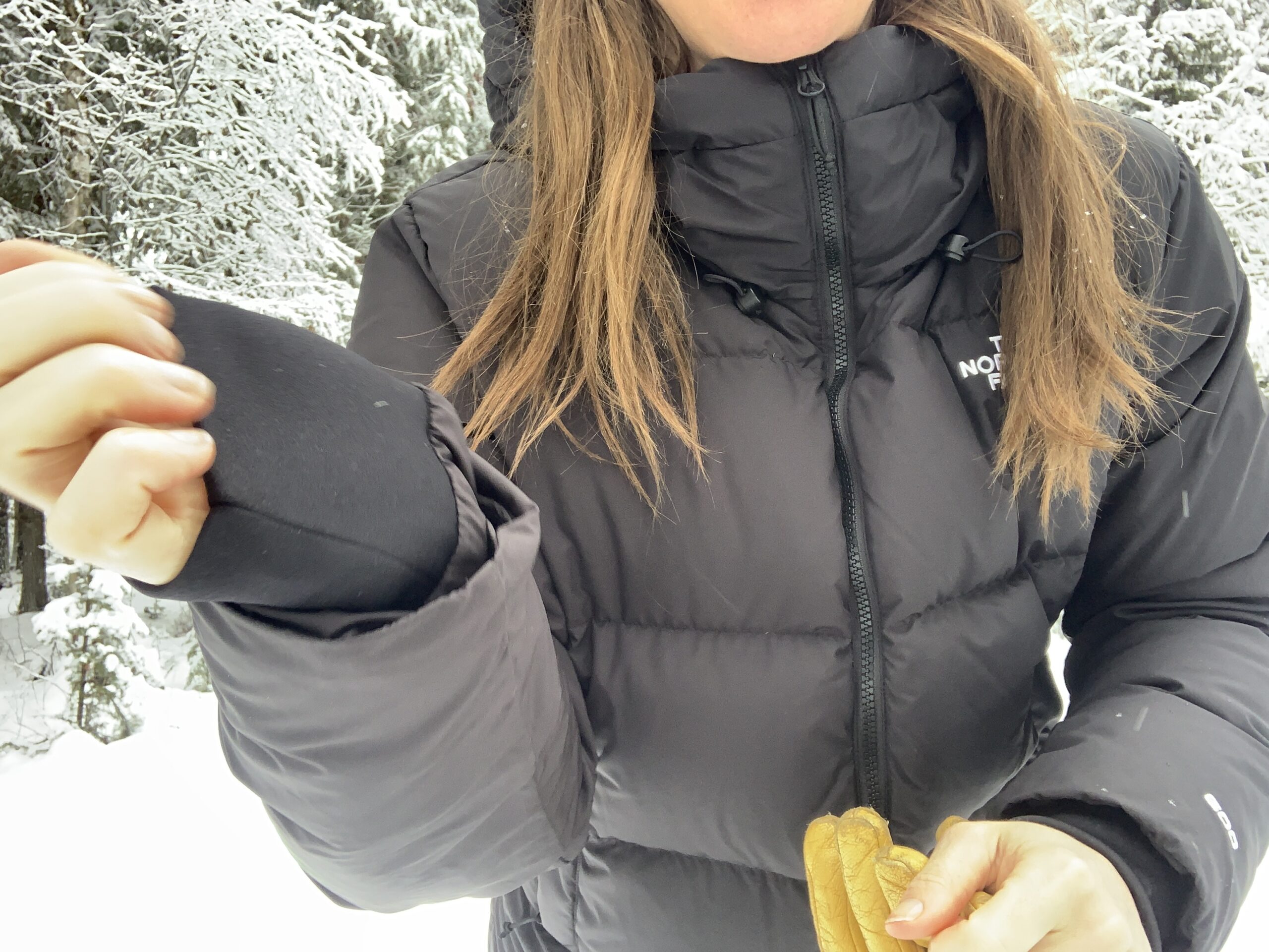 A woman wearing the north face triple c parka shows the wrist cuffs or gaskets as an additional feature