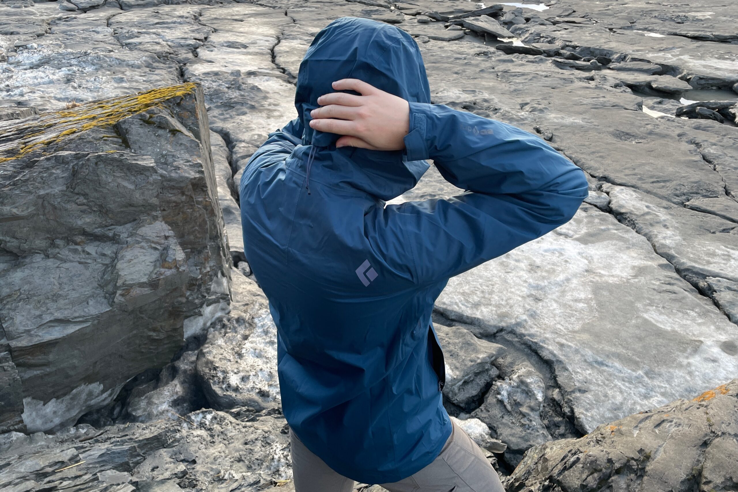 A man tightens the hood of his rain jacket.