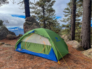 The Marmot Tungsten 2 pitched on pine needles among scattered rocks and pine trees.