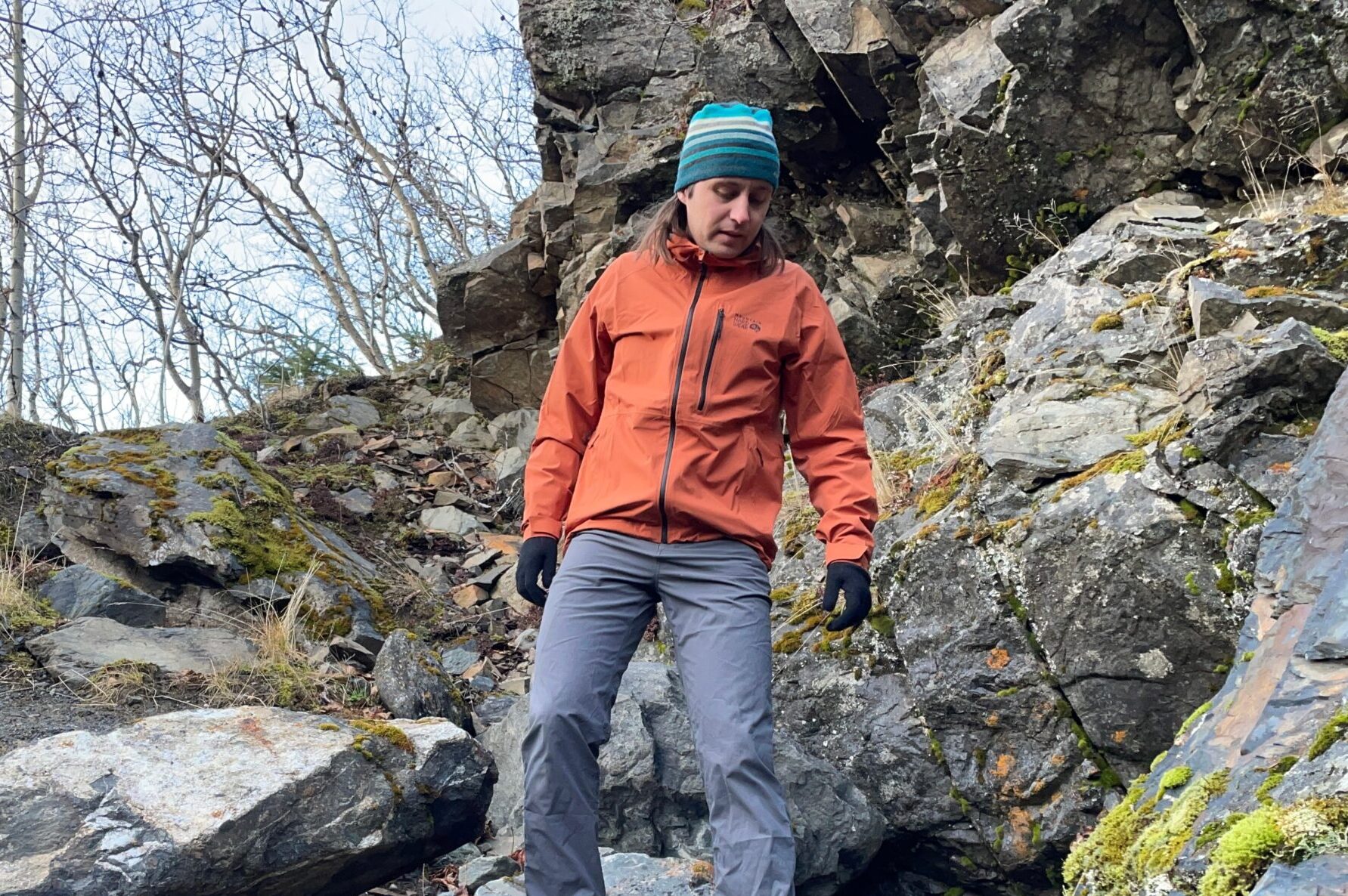 A man walks down a rocky trail.