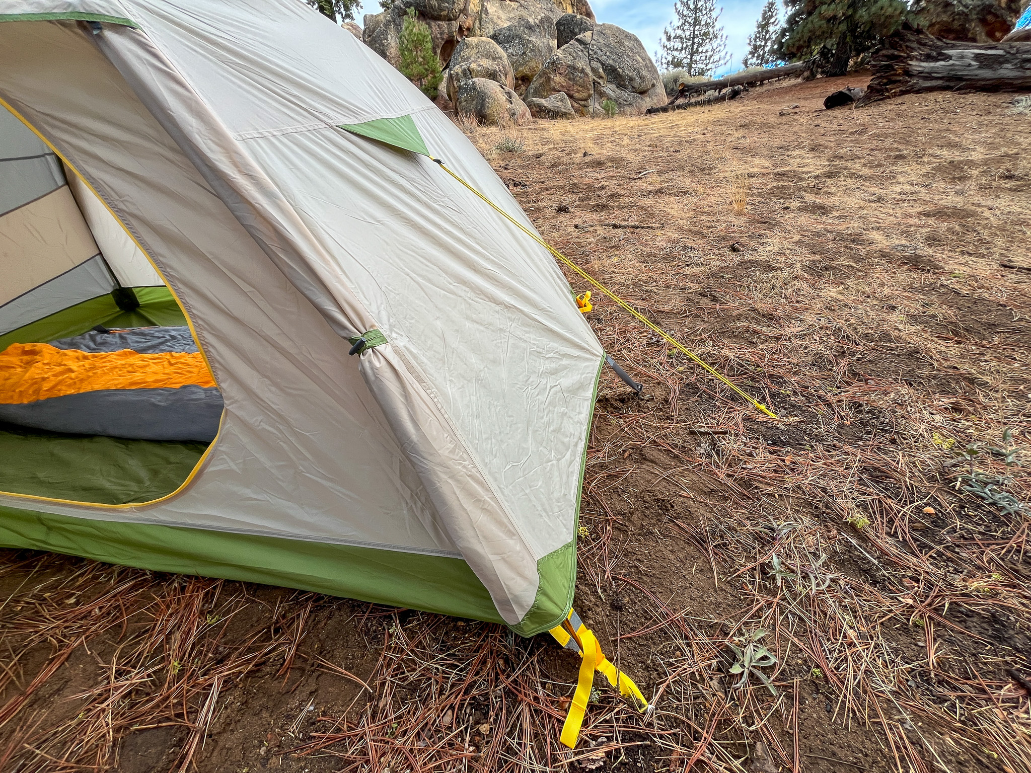 A closeup of the Mountainsmith Morrison EVO 2's tension points, showcasing its sturdy construction and secure guy lines anchored to the ground in a outdoor setting.