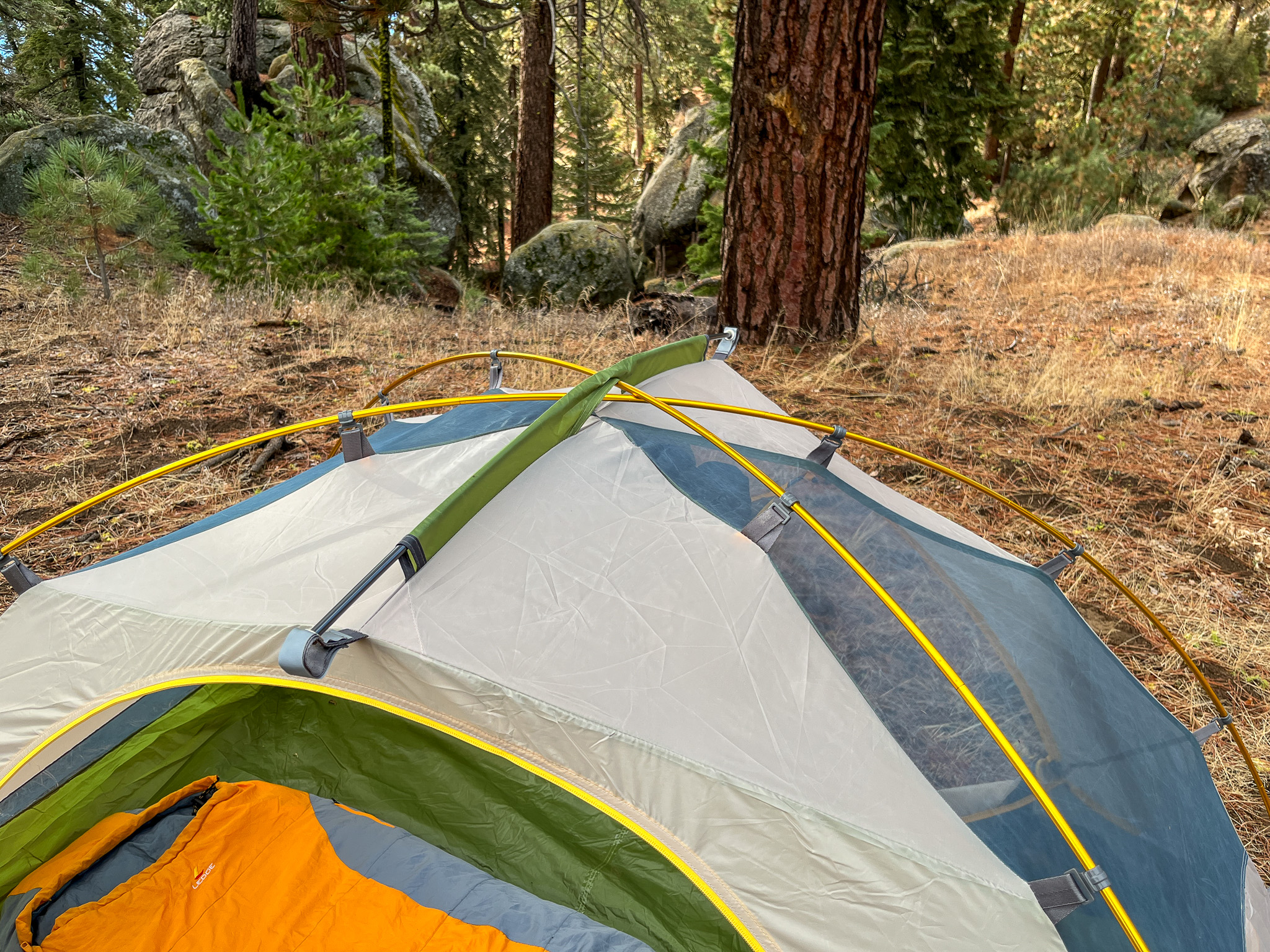 A closeup of the Mountainsmith Morrison EVO 2 pole structure, showing the apex intersection. Forest in the background.