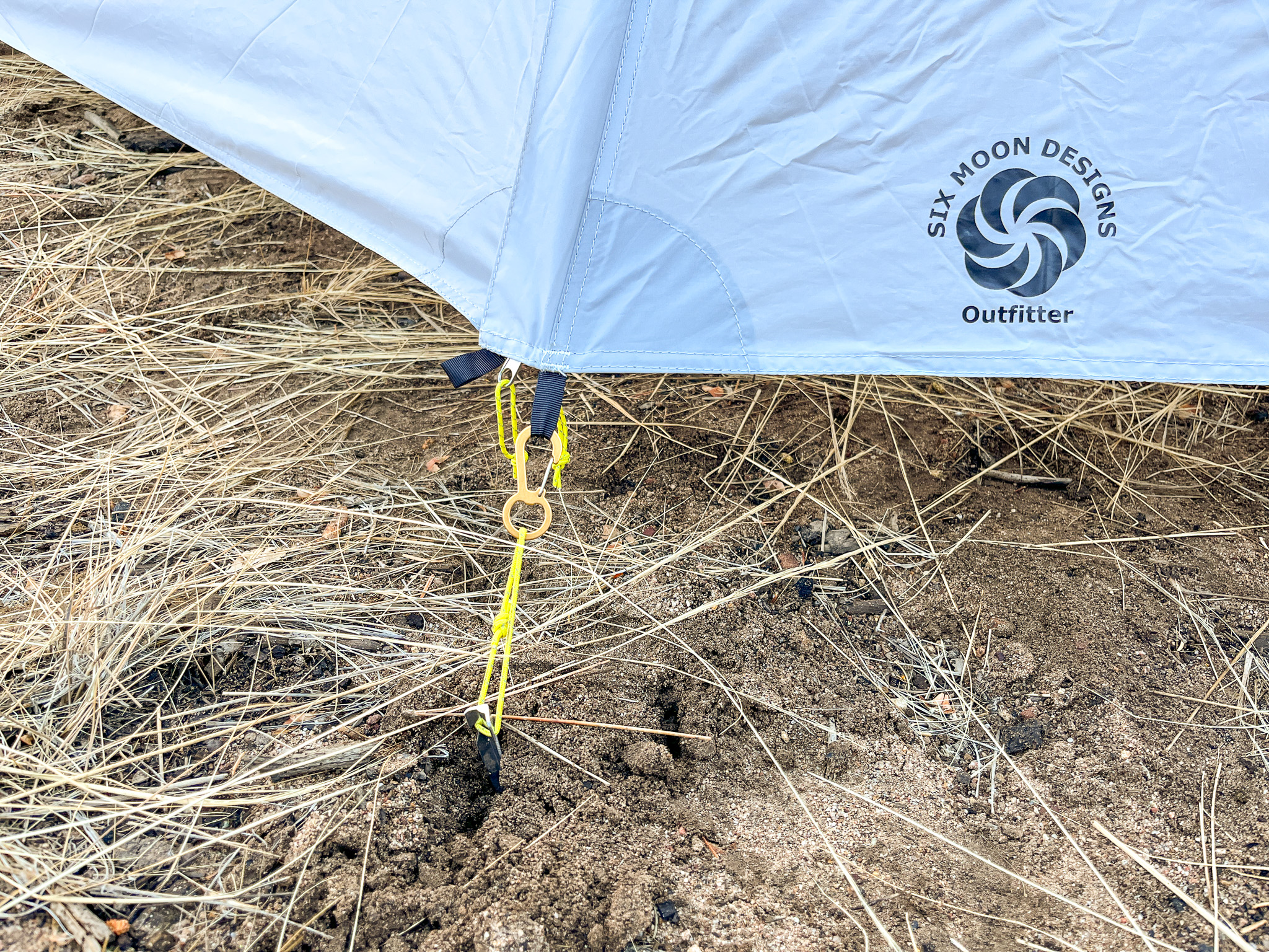 Close up view of one of the reinforced vestibule anchor points on the canopy. It shows guy line and webbing loops plus an attached carabiner ring clip.