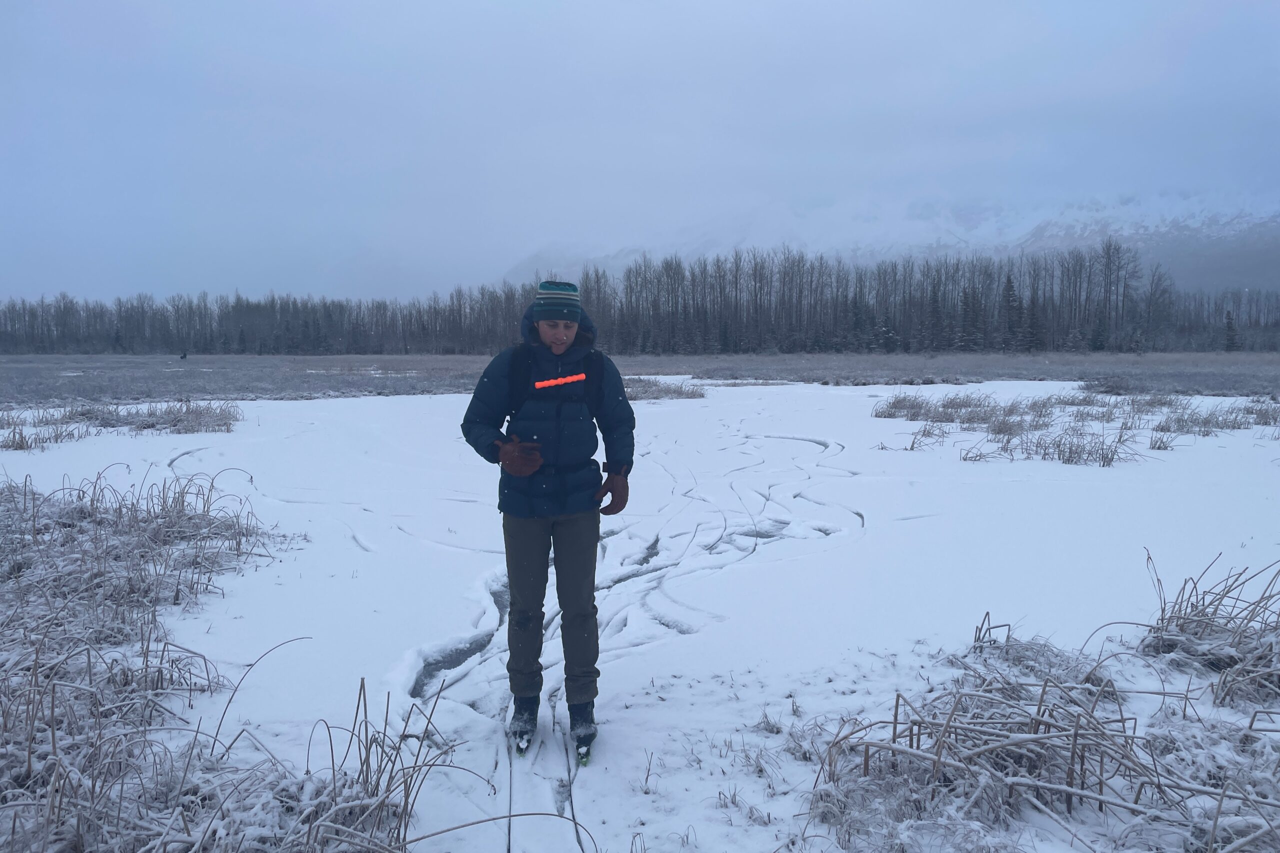 A man ice skates on a snowy pond.