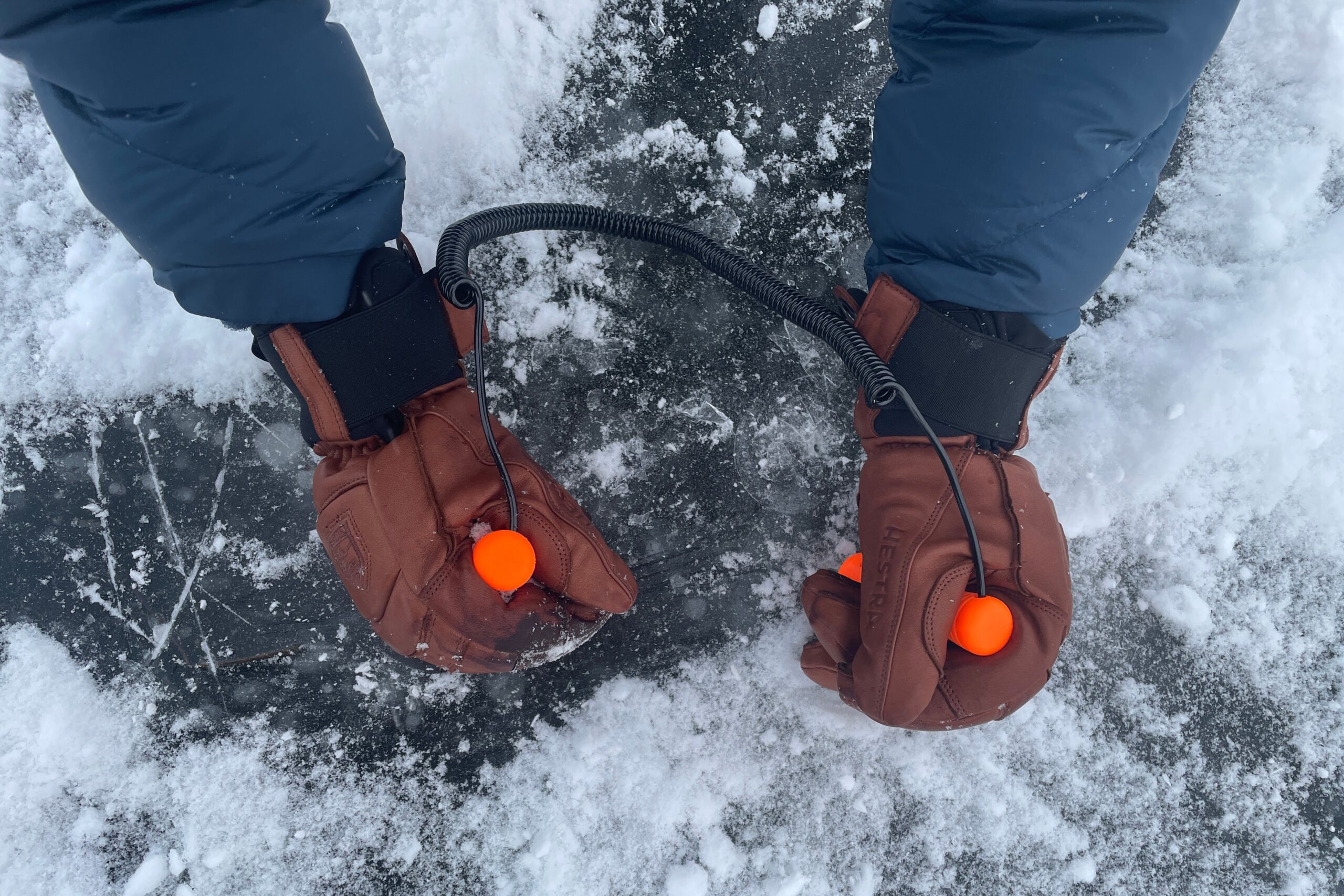 A man grabs ice picks with winter gloves.